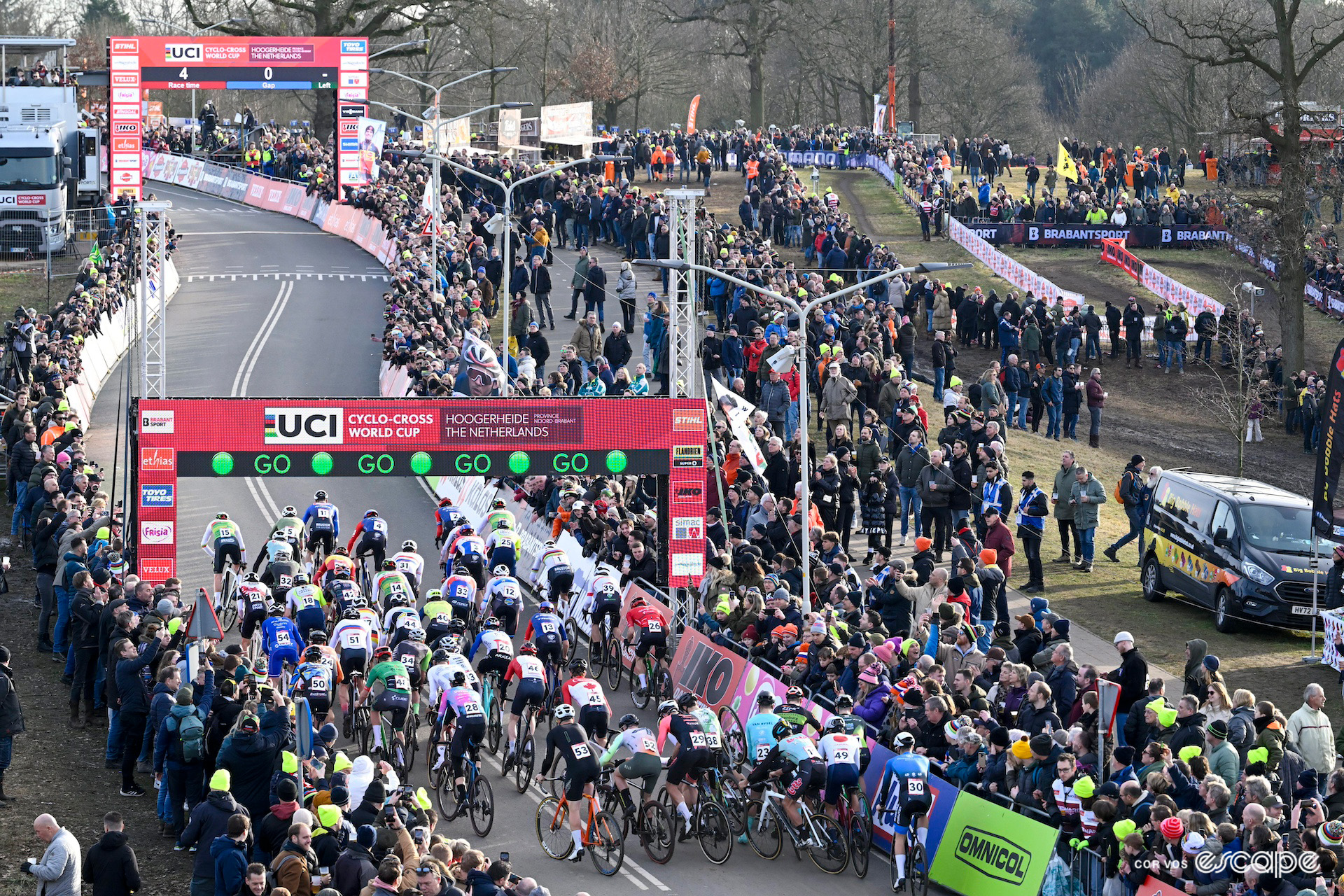 A wide view of the elite men's start at CX World Cup Hoogerheide, showing the moment of a crash deep in the pack as the race got underway.