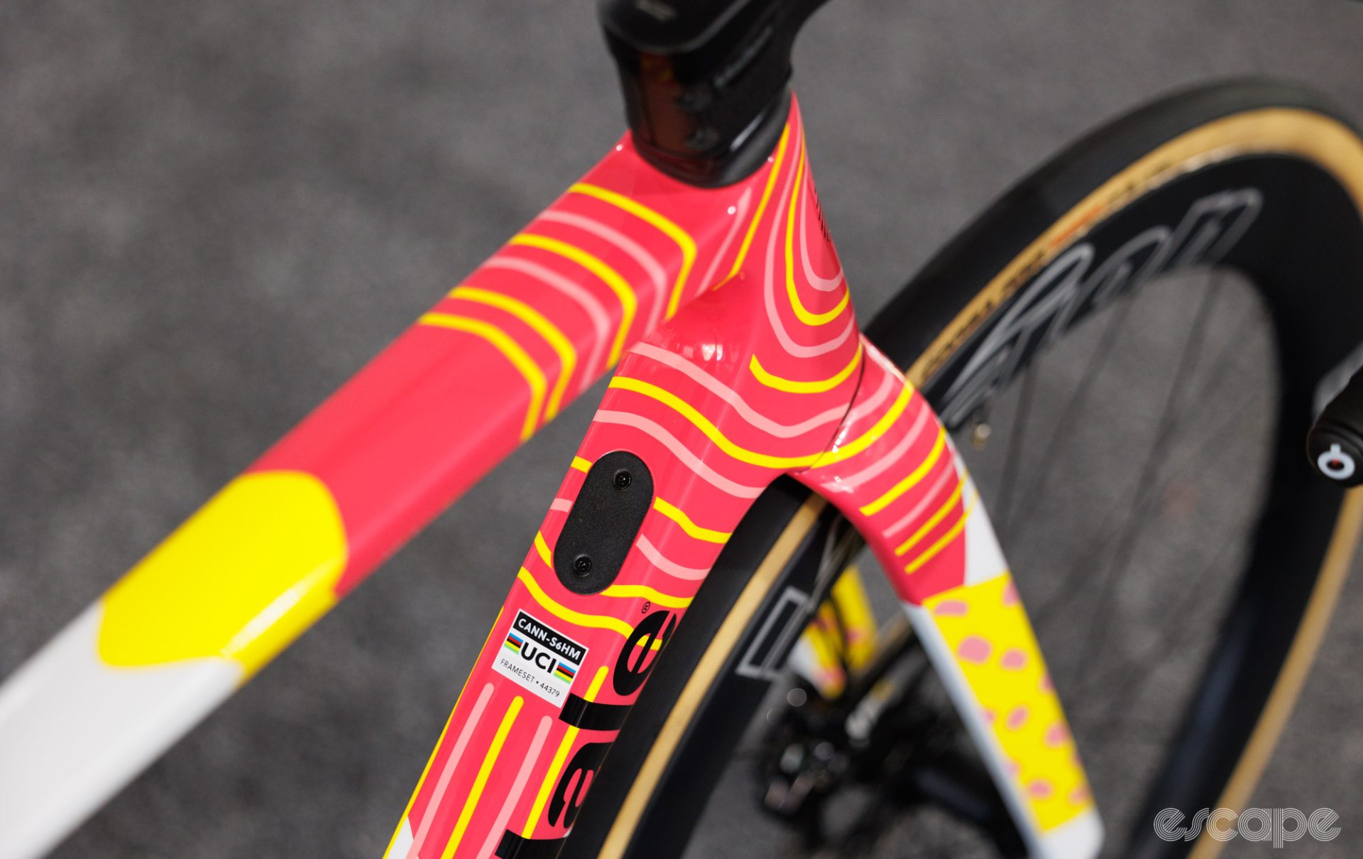 The colorful paint hides some aero features like a squared-off down tube. A Di2 control port is also shown.
