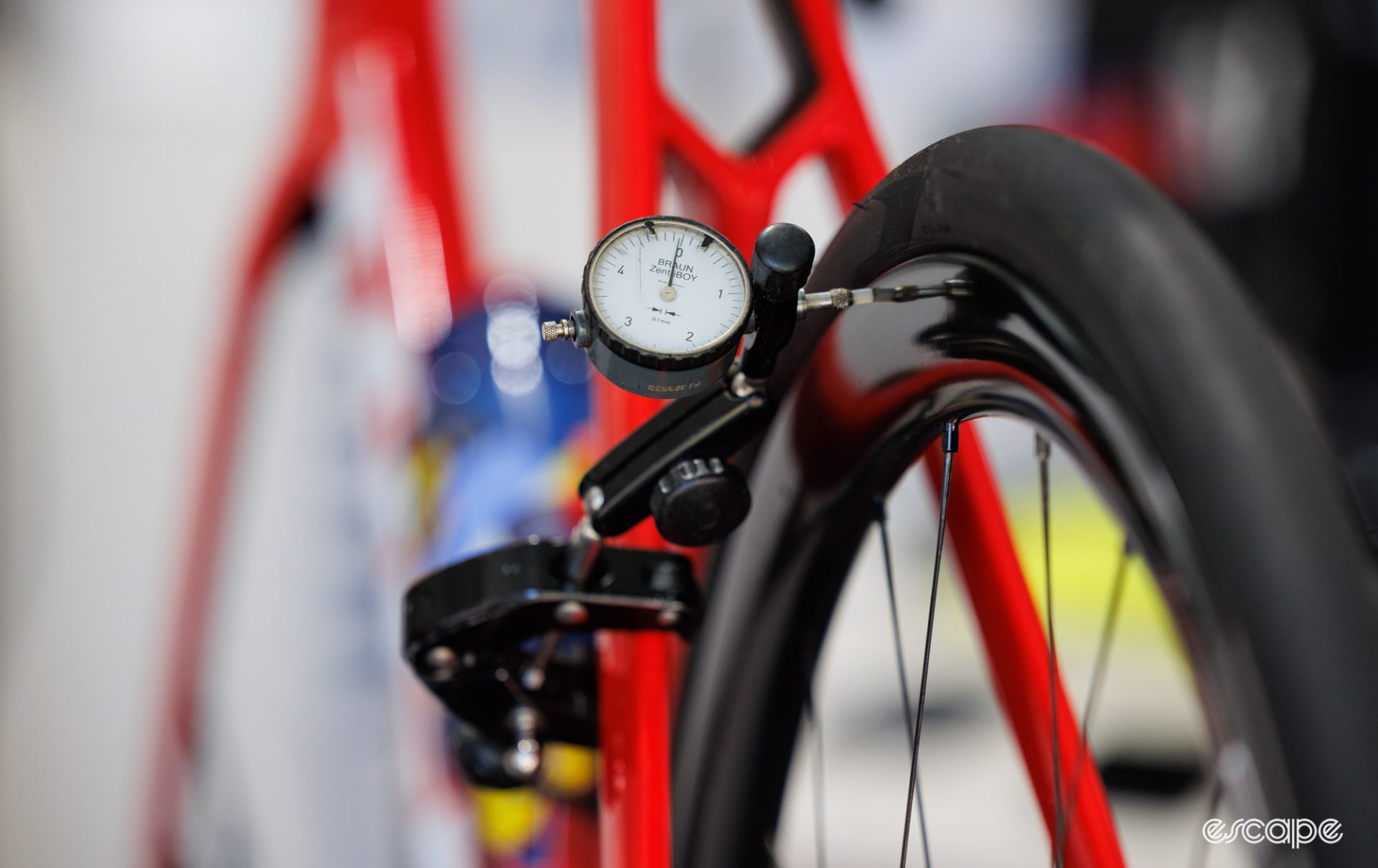 A measuring gauge is clamped to the seatstay of a red Trek. 