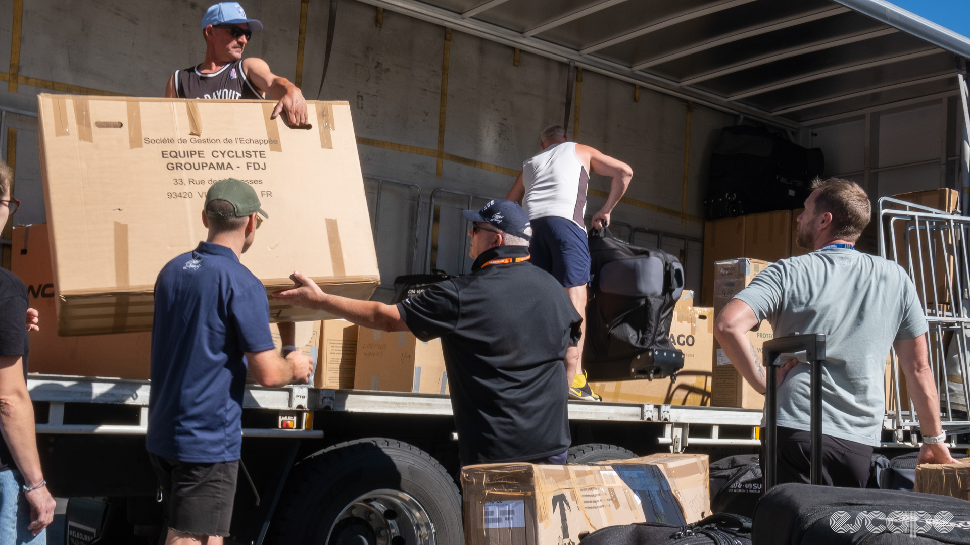 The photo shows staff members and haulage company staff loading the truck. 