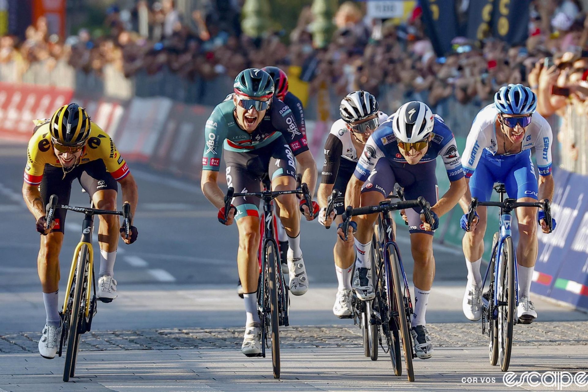 From left to right, Primož Roglič, Aleksandr Vlasov, Adam Yates, Andrea Bagioli, and Simon Yates sprint at Il Lombardia. Obscured behind Vlasov is Carlos Rodriguez. Not shown is winner Tadej Pogačar. Vlasov's mouth is open wide.