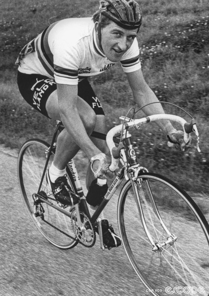 Freddy Maertens looks slightly sideways toward the camera in a shot in a 1977 road race. He's wearing the rainbow jersey he won the previous fall.