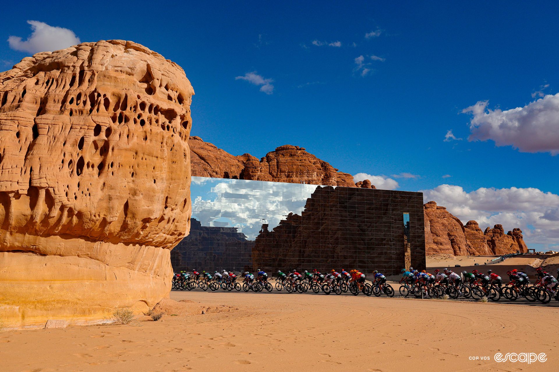The peloton zips past the Maraya Concert Hall at the recent AlUla Tour, the largest mirrored building in the world.