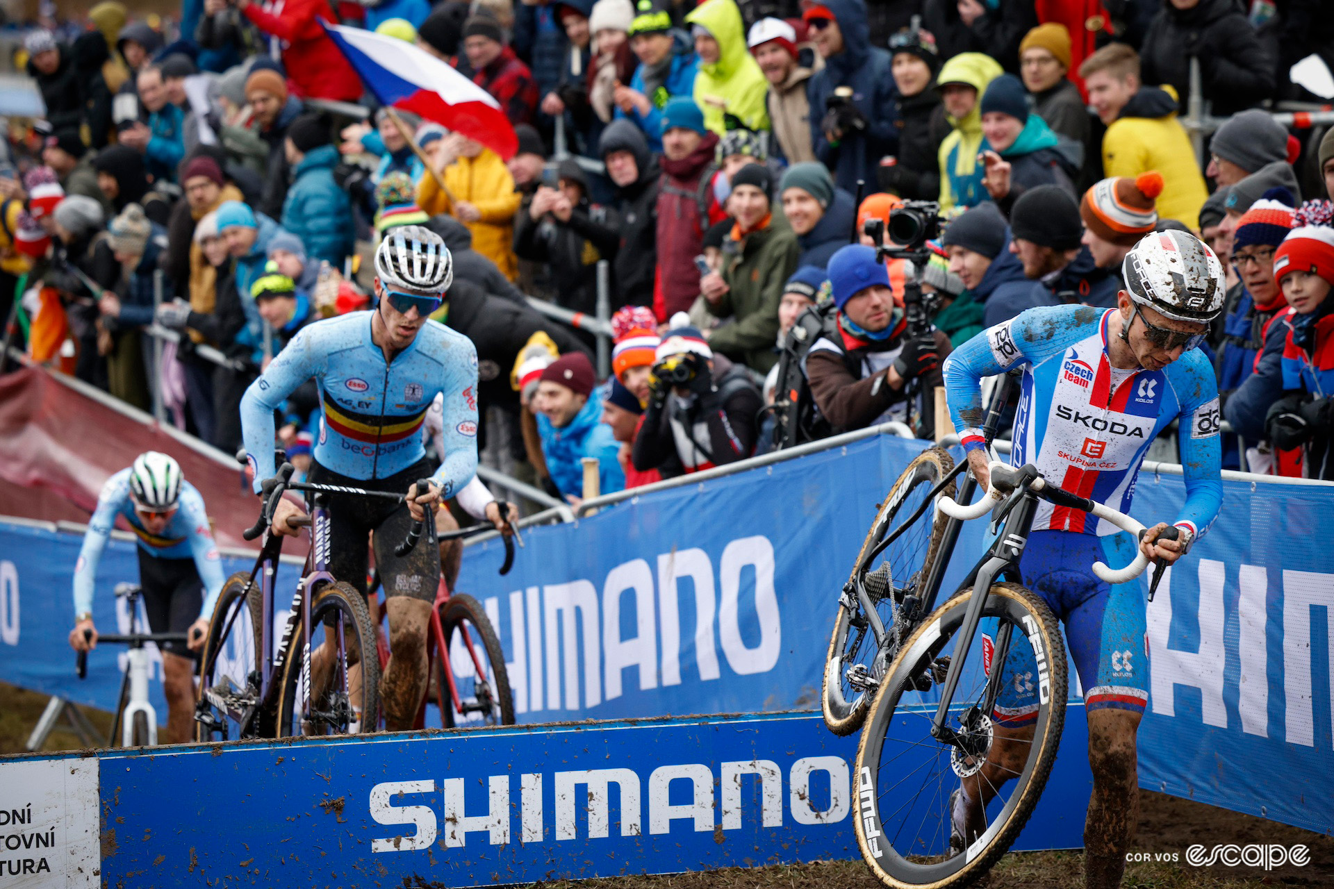 Czech rider Michael Boroš lifts his bike over the planks ahead of Belgian Niels Vandeputte during the 2024 Cyclocross World Championships in Tábor.