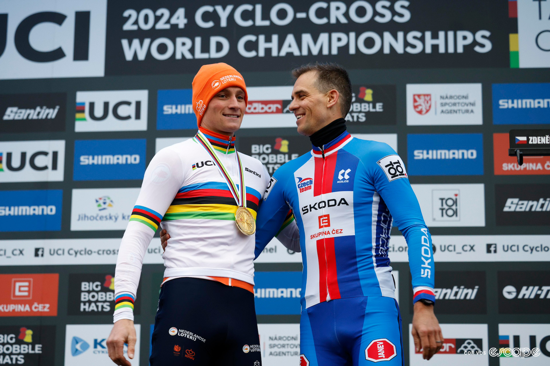 Mathieu van der Poel, wearing a new rainbow jersey and gold medal, embraces retiring Czech rider Zdeněk Štybar on the podium after the 2024 Cyclocross World Championships in Tábor.
