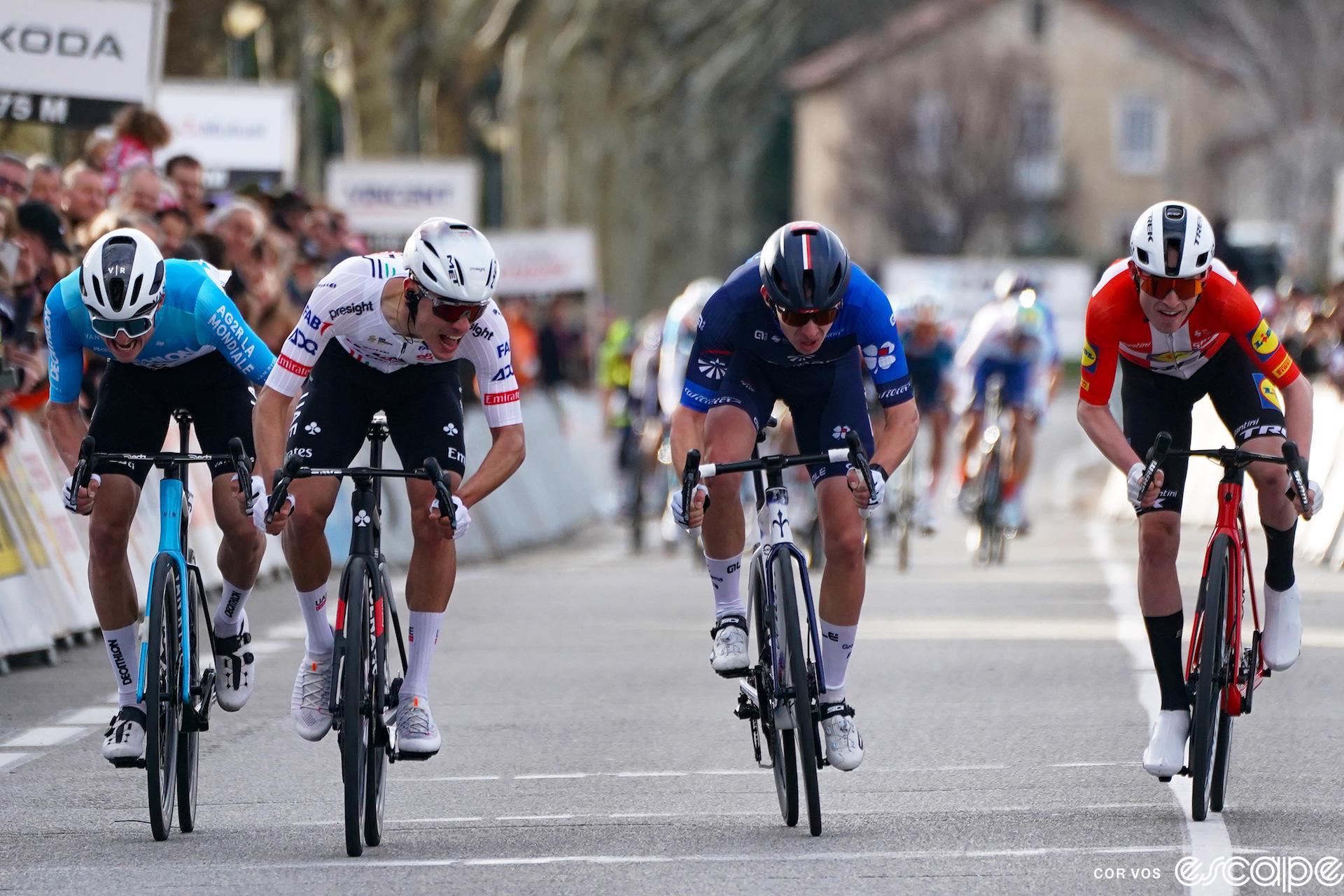 From left to right, Felix Gall, Juan Ayuso, Lenny Martinez, and Mattias Skjelmose sprint out the win at the 2024 Faun Ardeche. All four are out of the saddle and grimacing from the effort.