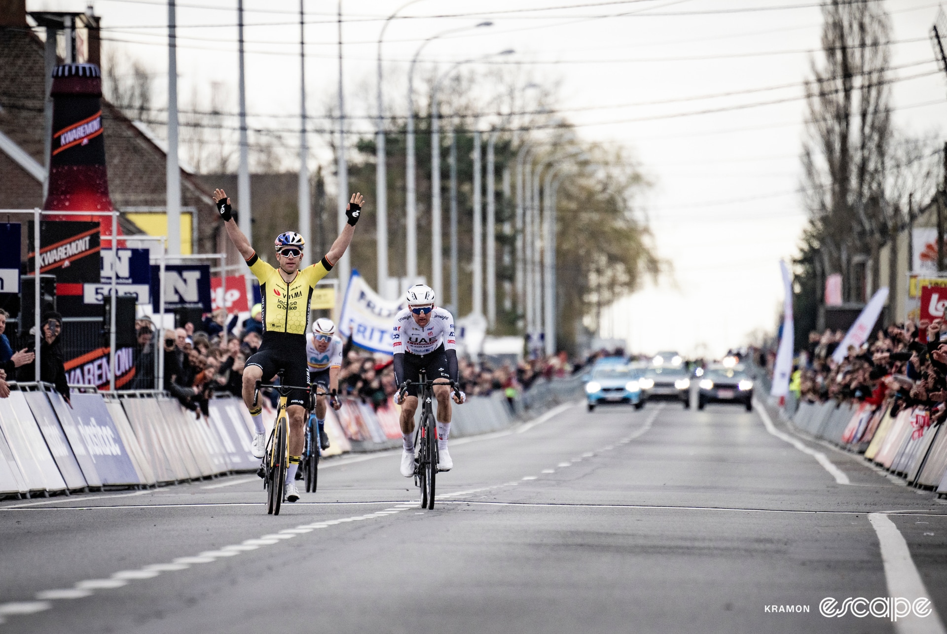 Van Aert celebrates winning with two hands in the air.