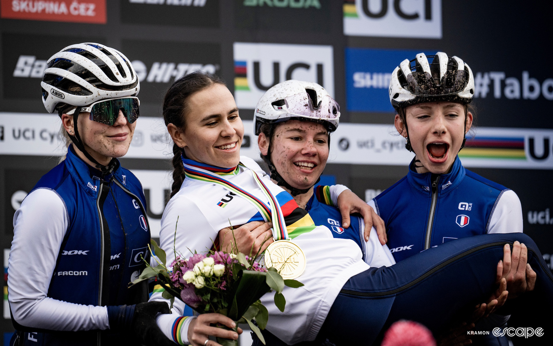 Célia Gery in the rainbow jersey is held aloft by her three French teammates on the junior women's podium at the 2024 Cyclocross World Championships in Tábor.