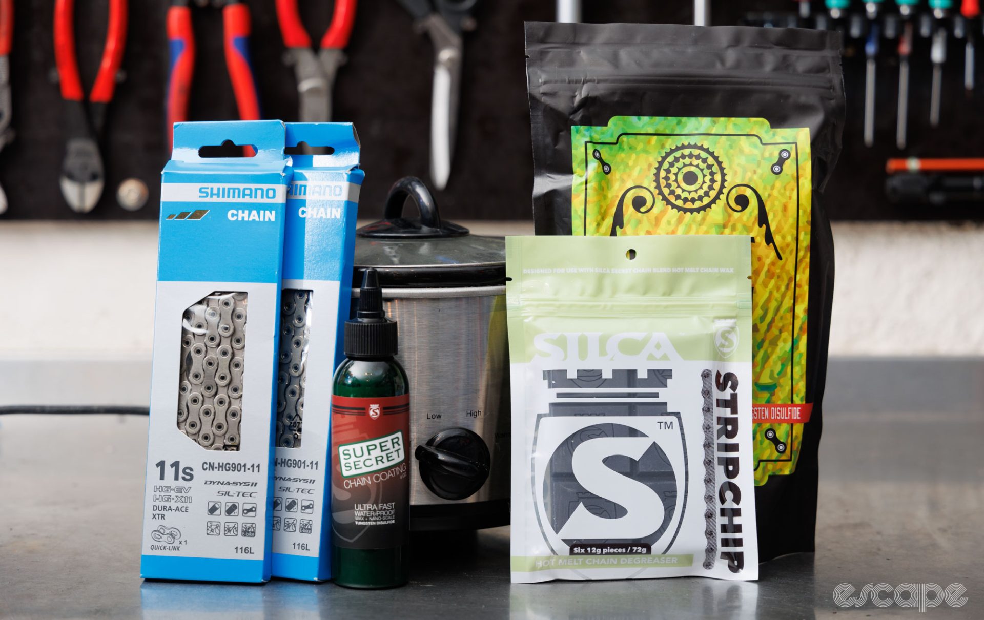 A handful of Silca chain products, along with Shimano chains and a slow cooker. All placed on a workbench. 