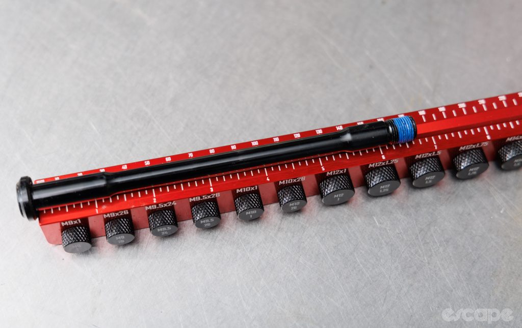 Wheels Manufacturing Axle Ruler Pro being used to measure the length of an axle. 