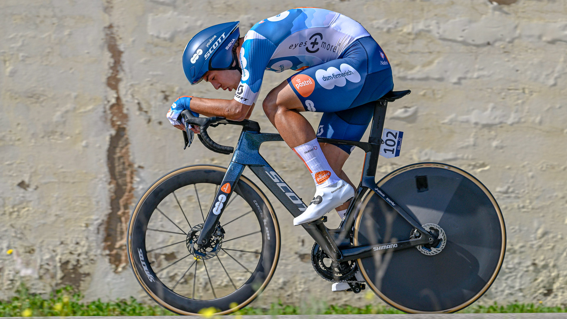 The image shows Pavel Bittner of Team dsm-firmenich PostNL time trialling on a road bike.