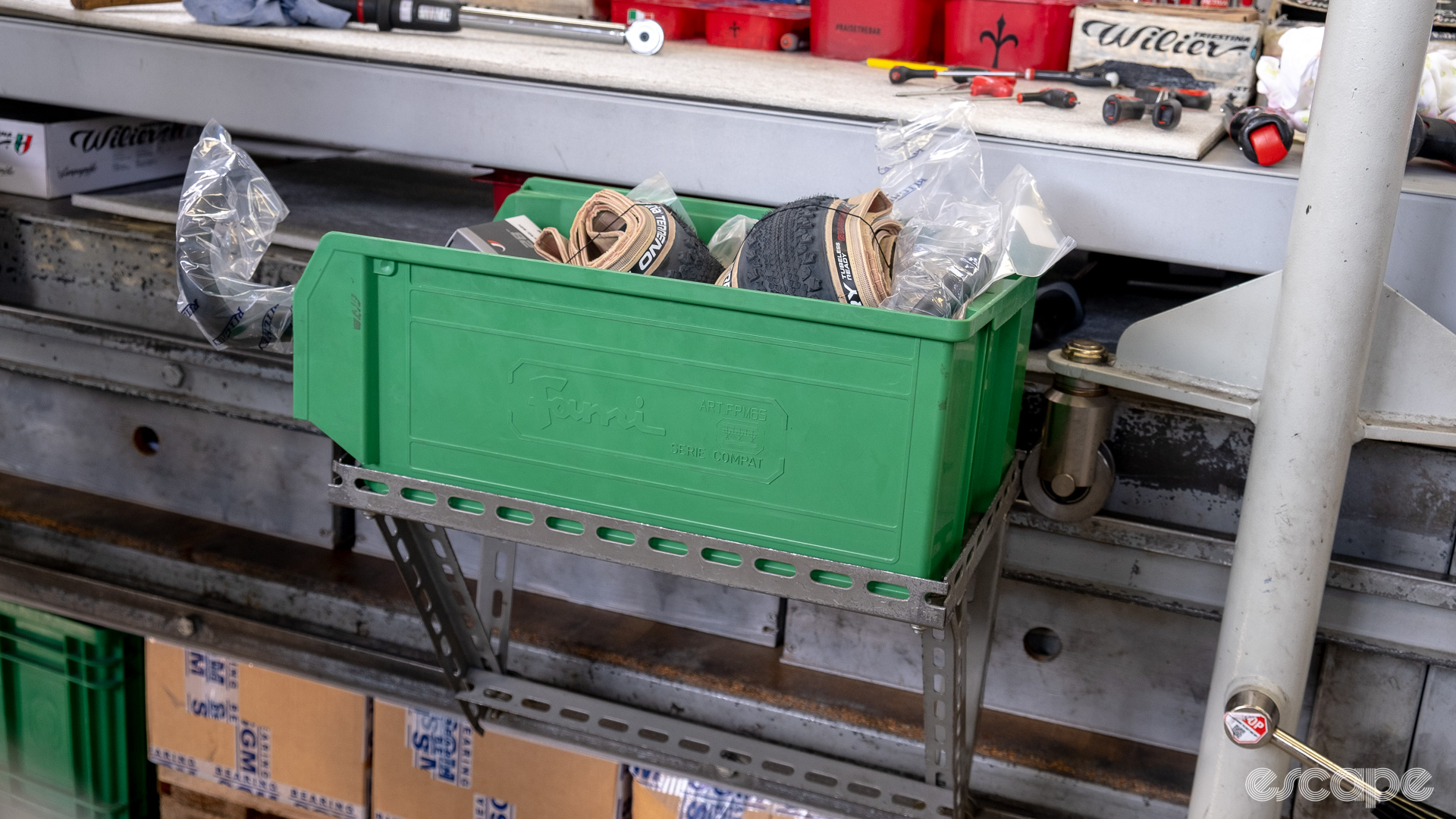 The photo shows the parts bin sat on a tray mounted to the assembly line.