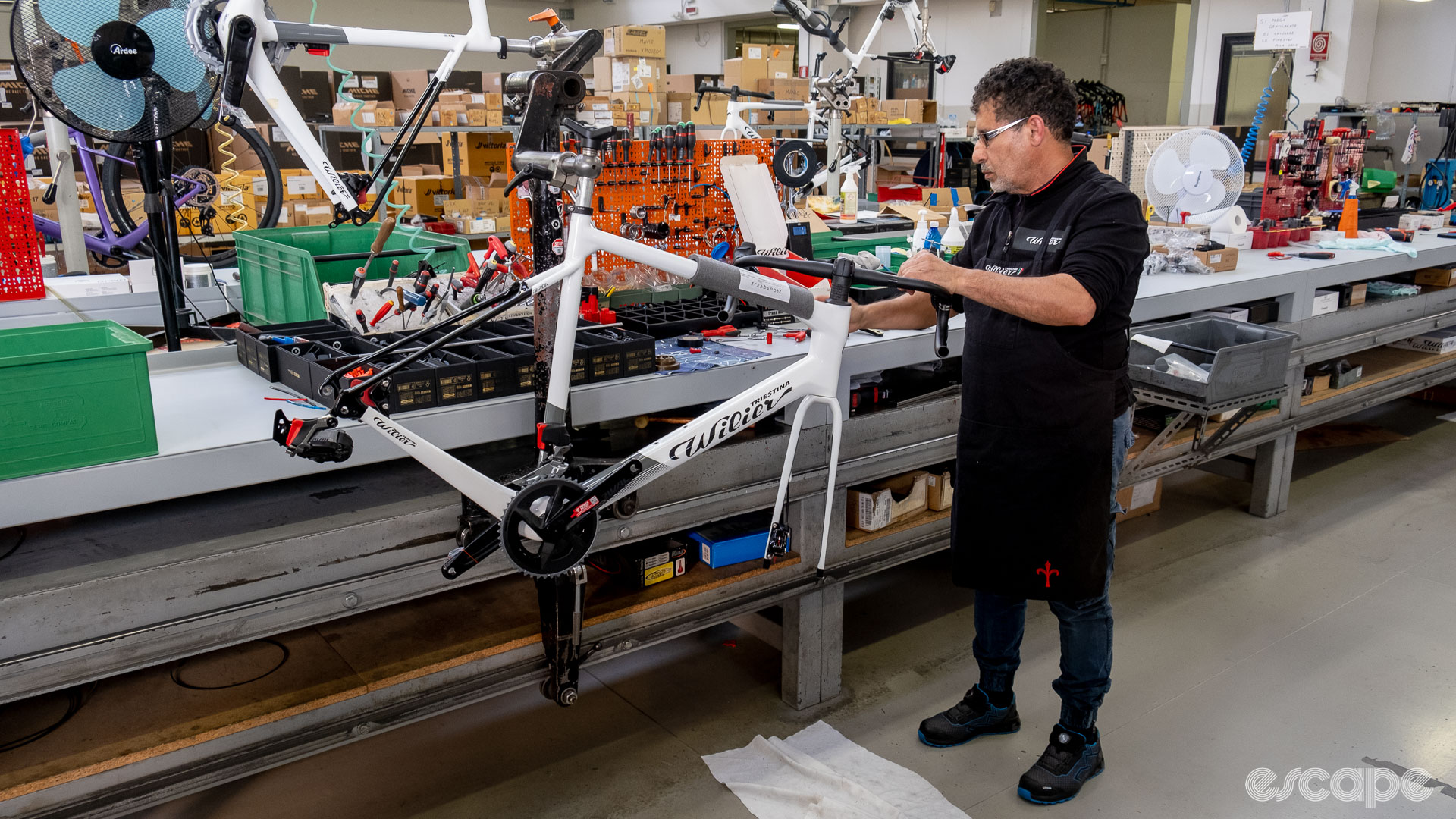 The photo shows a mechanic working at the Wilier assembly line.
