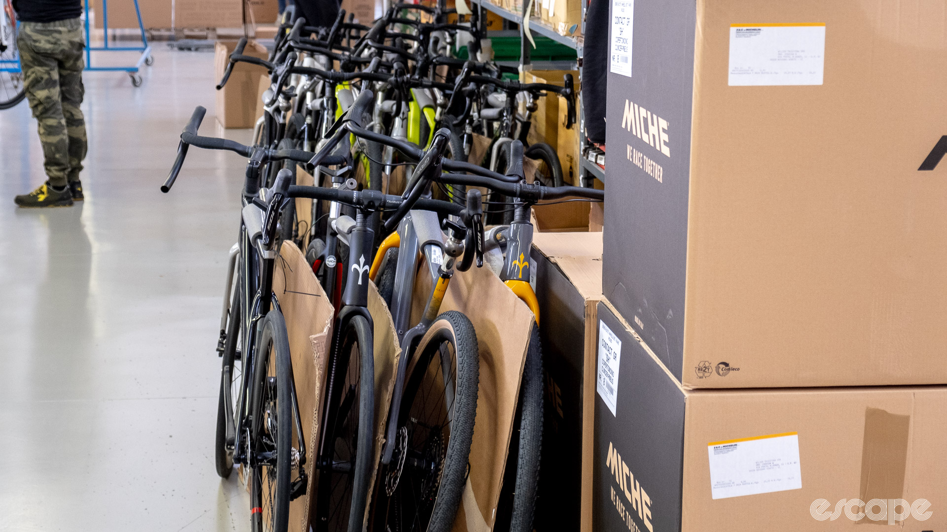 The photo shows a group of completed bikes waiting to be boxed. 