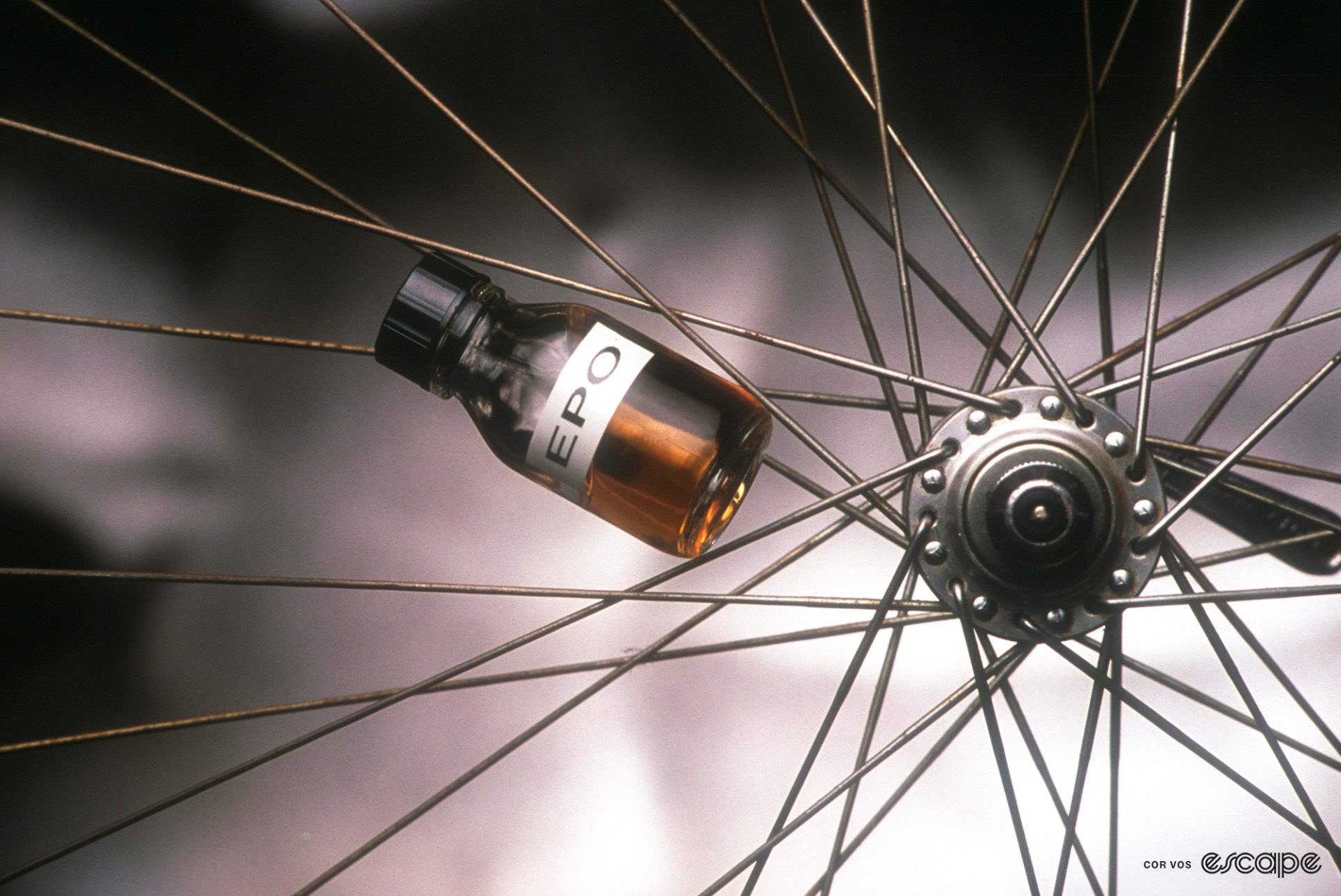A bottle of EPO in the spokes of a bike wheel.