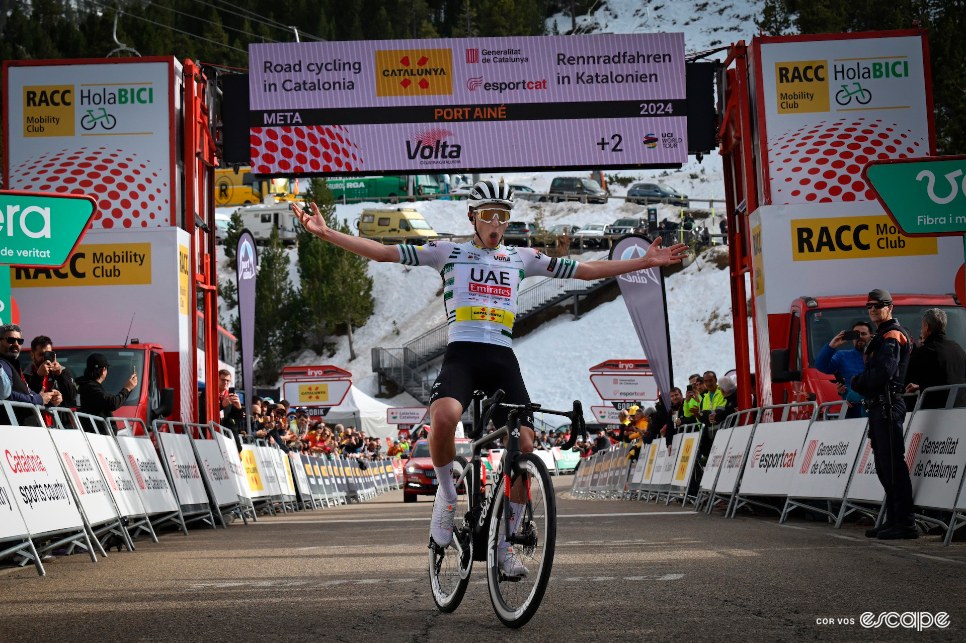 Tadej Pogačar throws his arms wide as he crosses the finish line for a stage win at the Volta a Catalunya.