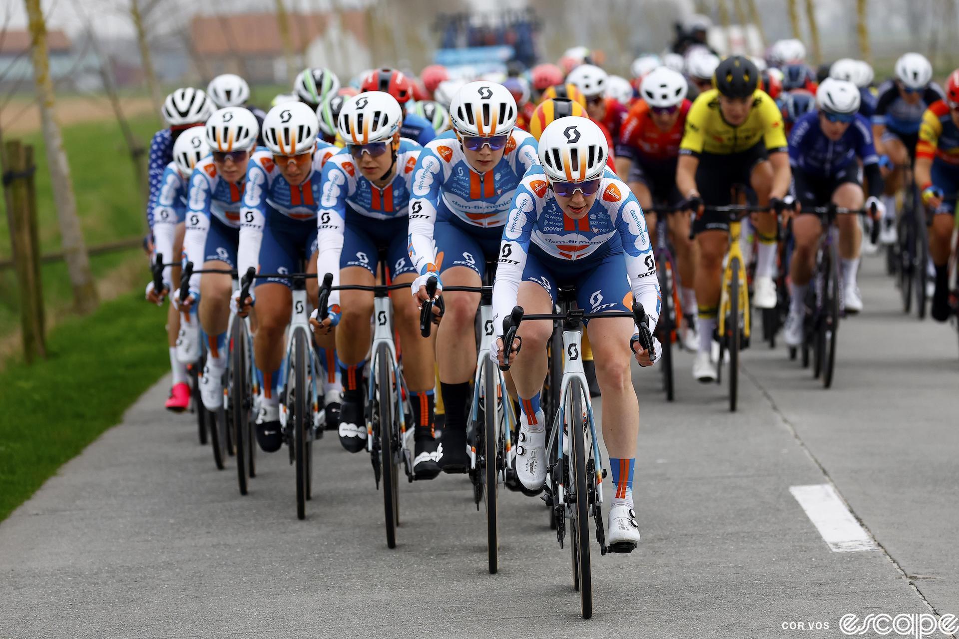 DSM Firmenich-PostNL riders are fanned out across the front of the pack at Brugge-De Panne while other teams sit in behind.