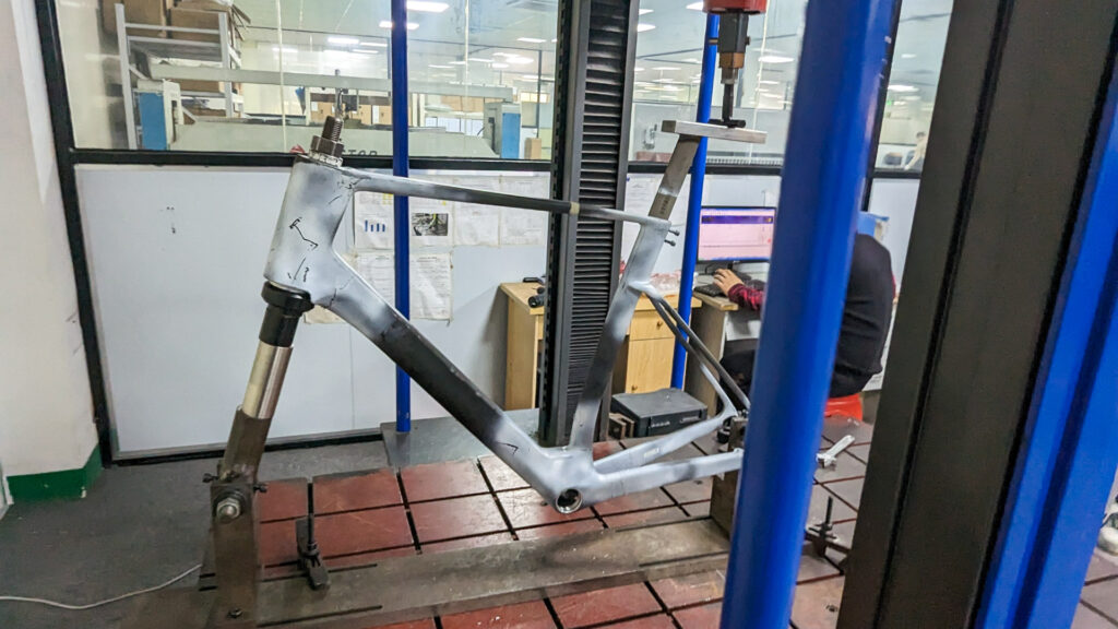 The image shows a frame on a test jig pressing a load through the seat post. 