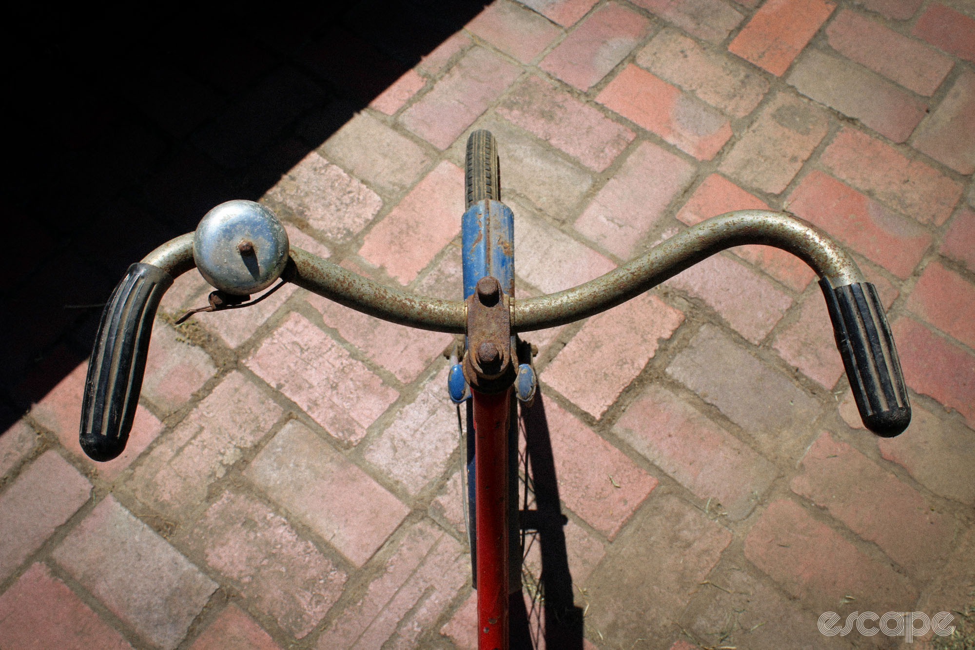 A view from above of a pair of rusty backswept handlebars.