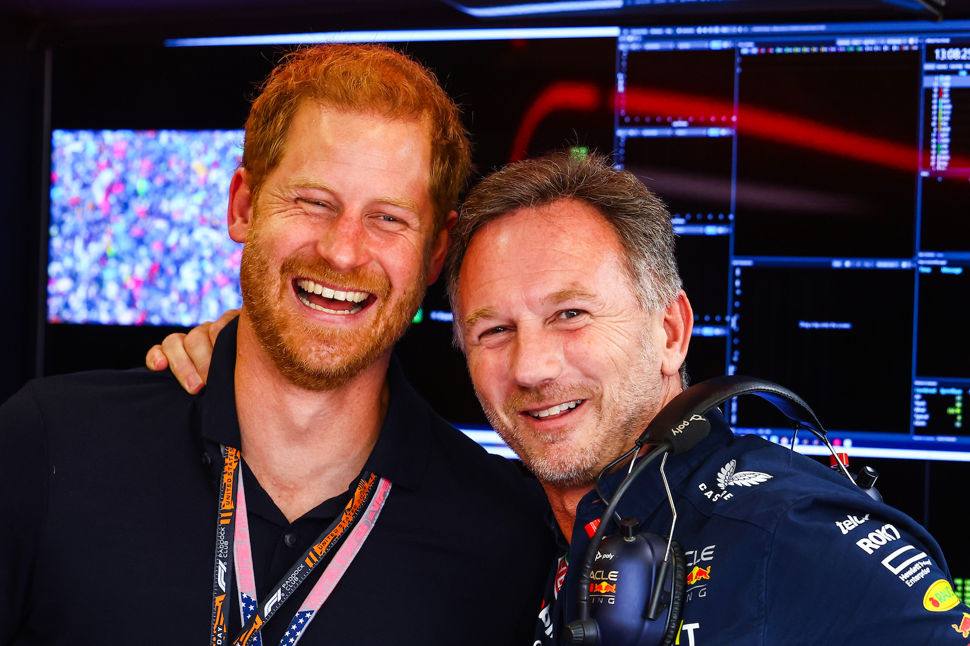 Prince Harry shares a laugh with Red Bull team principal Christian Horner at the Austin GP. Both are looking at the camera and Horner has his hand on Harry's opposite shoulder.