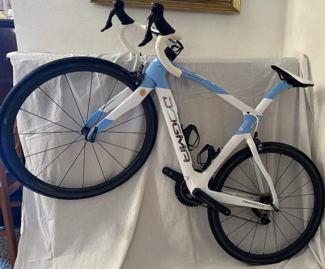 The bike is raised up on one wheel, its handlebars clumsily resting on a piece of furniture draped in a white sheet. 
