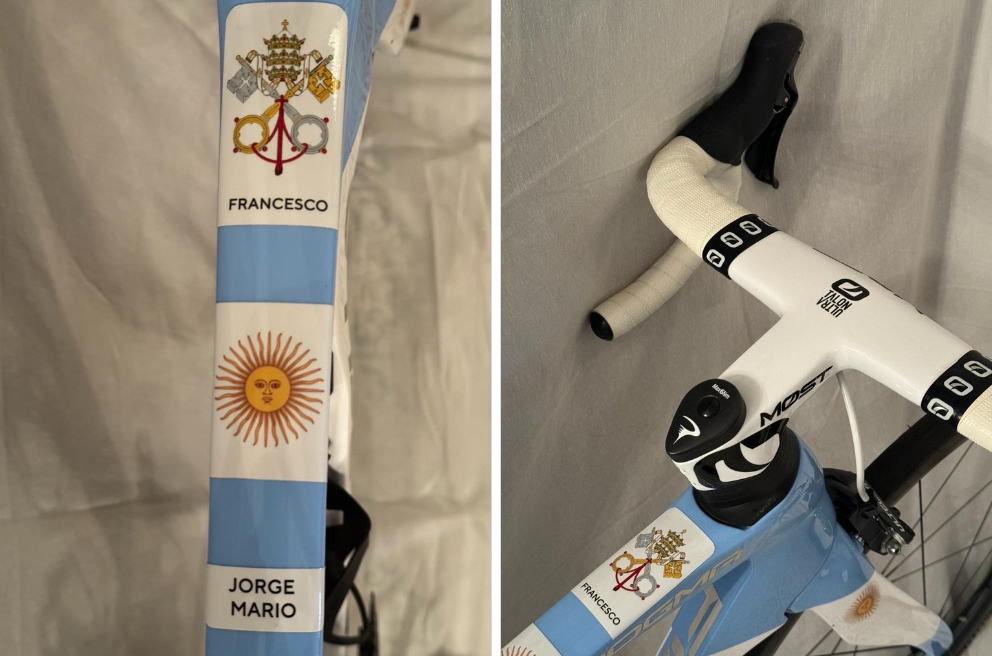 Left: a view of the top tube of the bike, with a papal seal and the words 'Francesco' above an Argentine sun and the words 'Jorge Mario'. Right: the handlebars of the bike. 