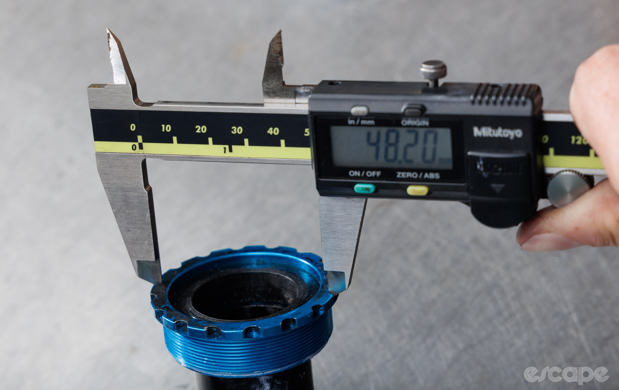 Measuring the diameter between two opposing tool notches with digital calipers. 
