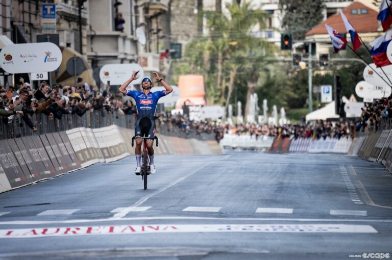 Mathieu van der Poel wins the 2023 Milan-San Remo. He is alone on the Via Roma finish, arms raised triumphantly in the air as he approaches the line.