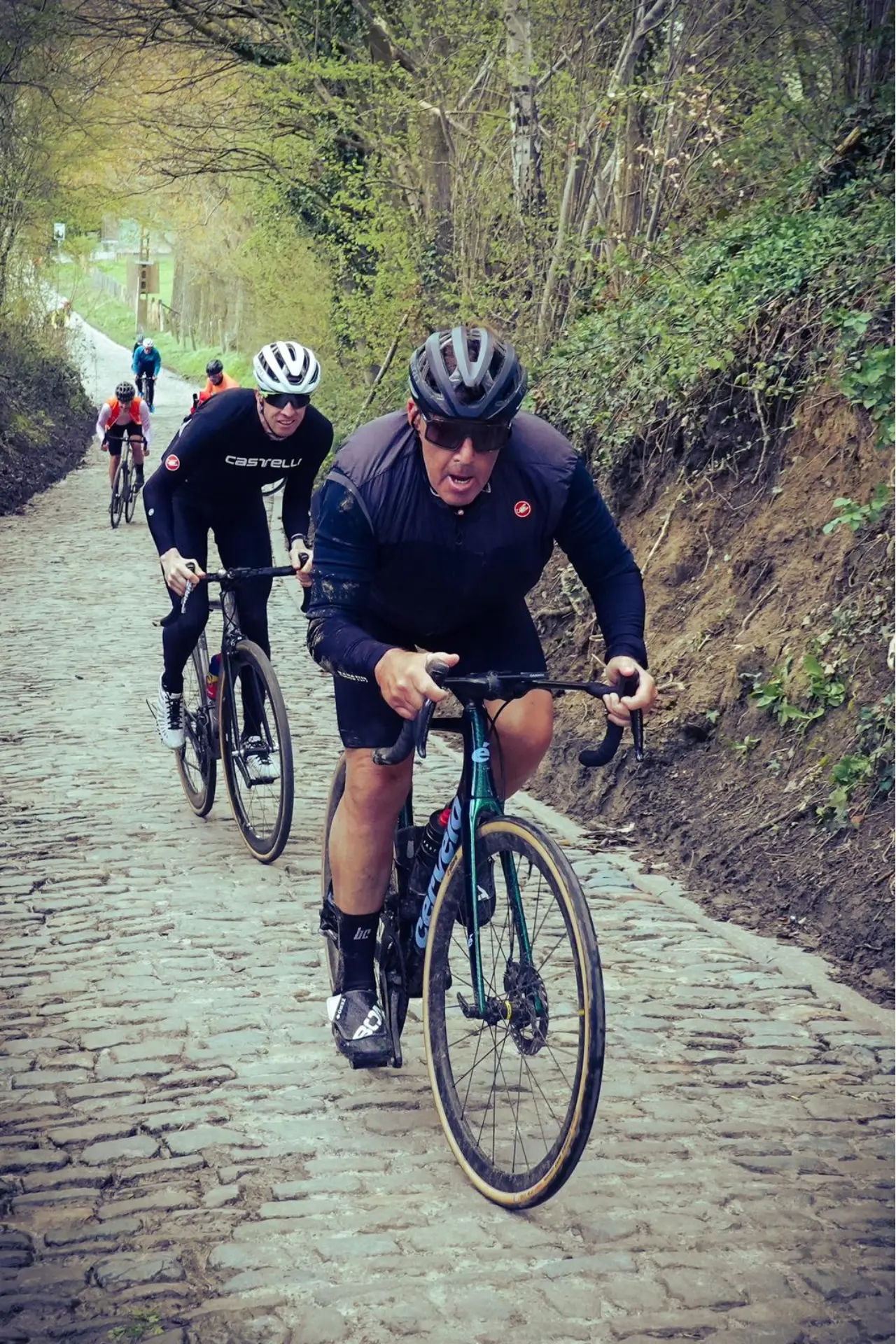 An action photo of Tony Unicomb riding up the Koppenberg