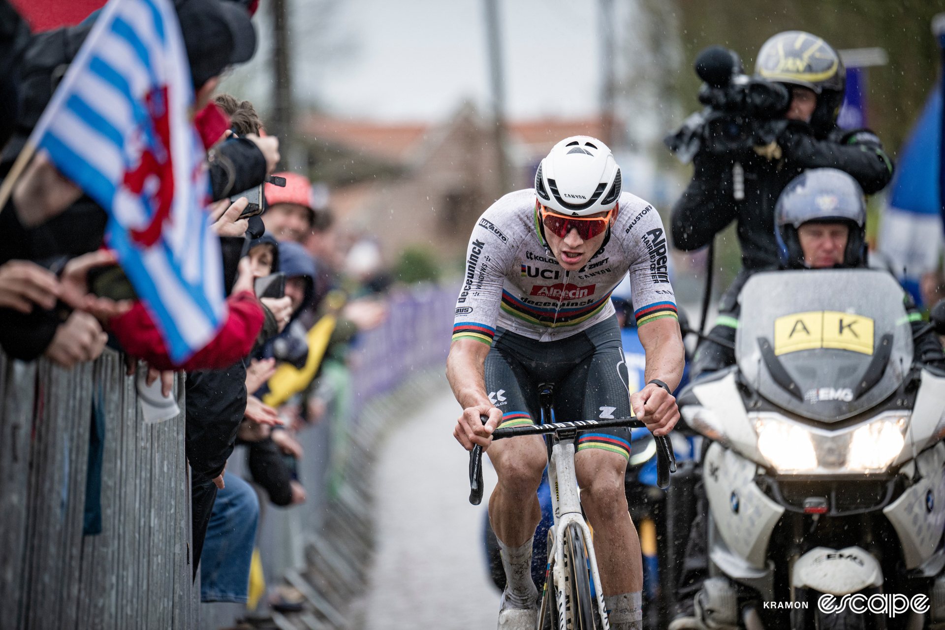 Mathieu van der Poel races in the rain at the Tour of Flanders. He's on the attack, alone late in the race and is trailed only by a TV moto and support vehicles with no other riders in sight.