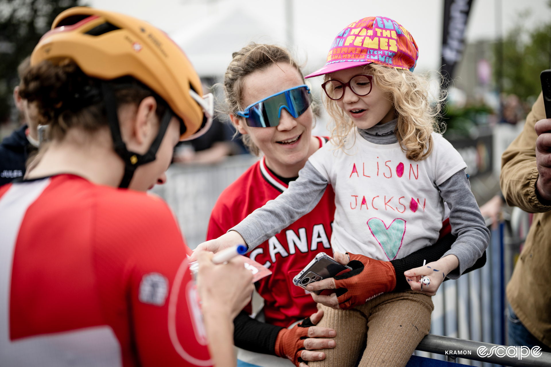 A woman and her daughter ask a professional cyclist for her autograph 