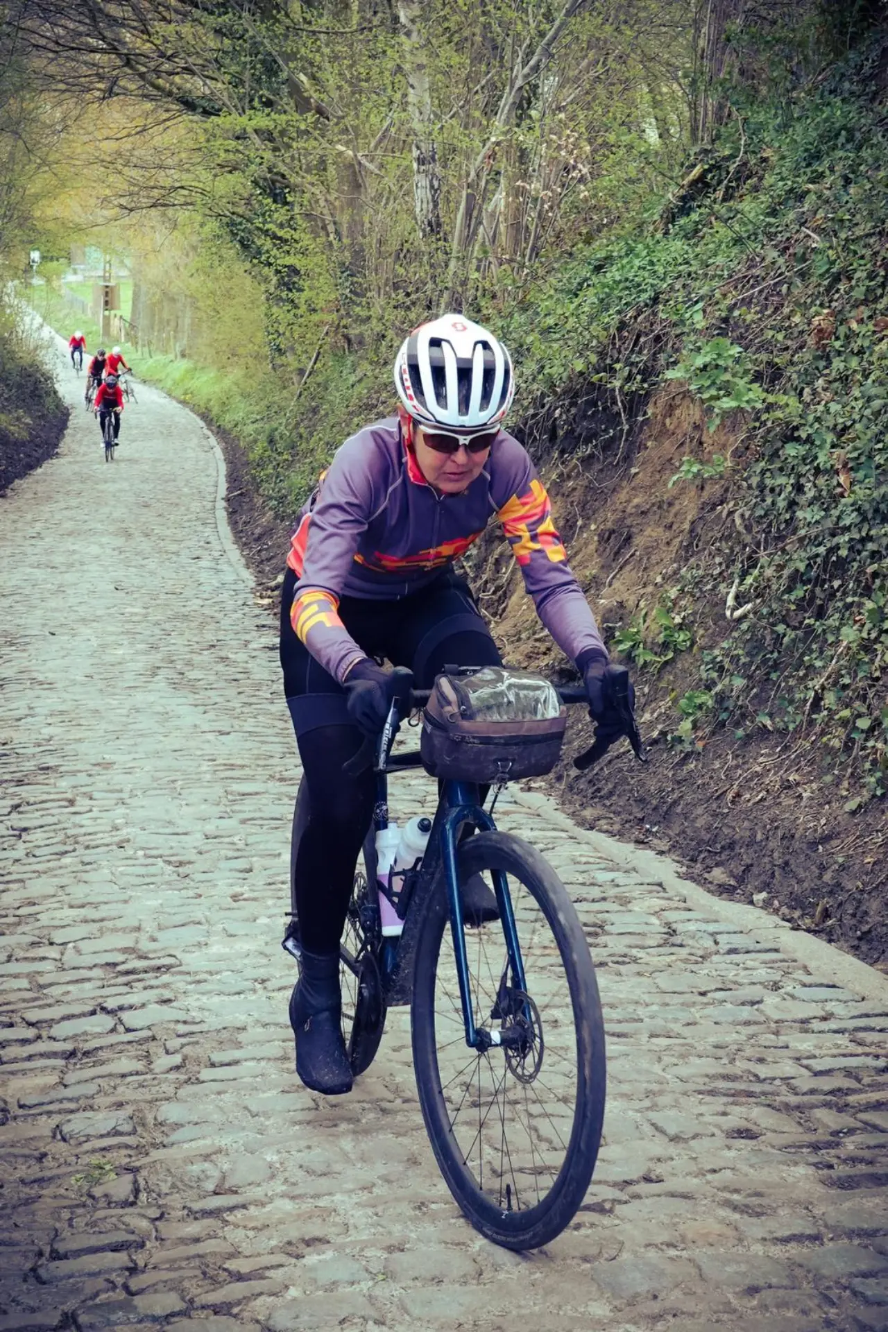 An action photo of Helen McCook riding up the Koppenberg