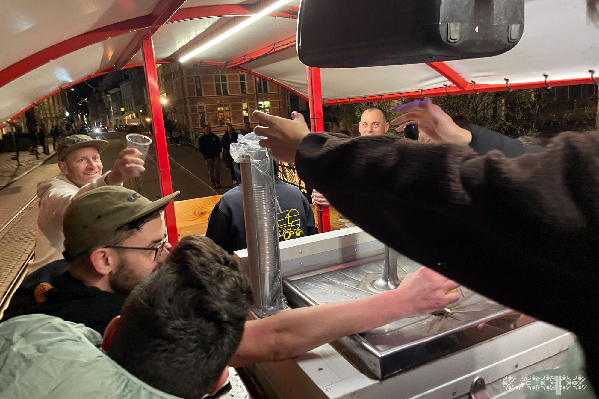 Many hands reaching across and toward the central beer tap.