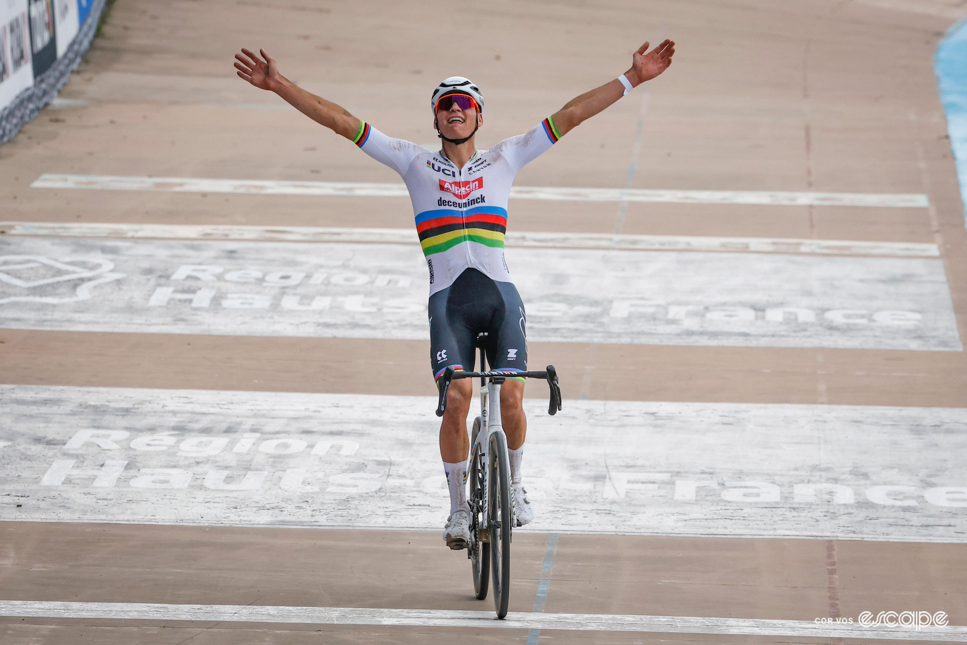 Mathieu van der Poel celebrates winning Paris-Roubaix in the Roubaix velodrome wearing the rainbow jersey of world champion.