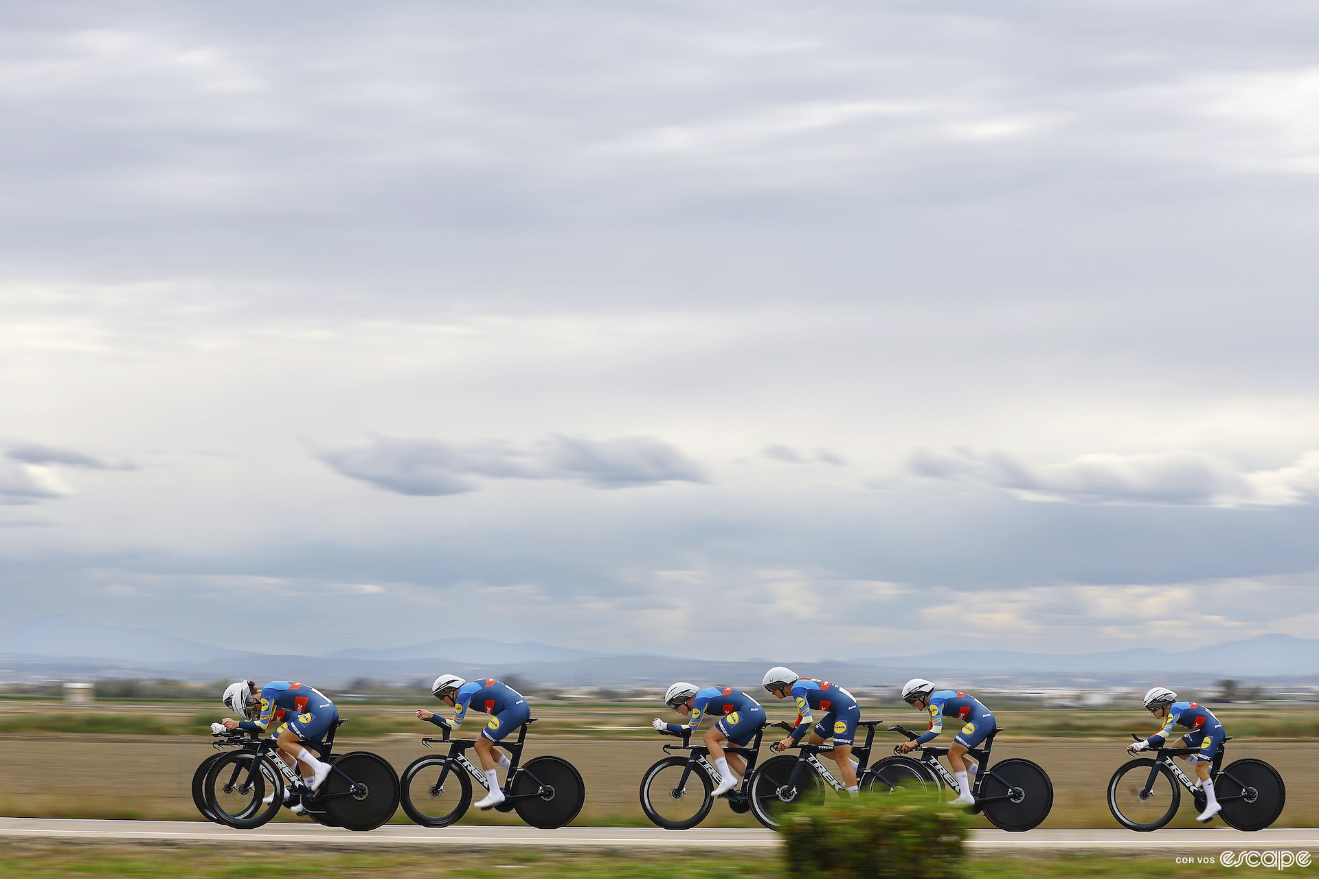 A line of women riding time trial bikes in a race