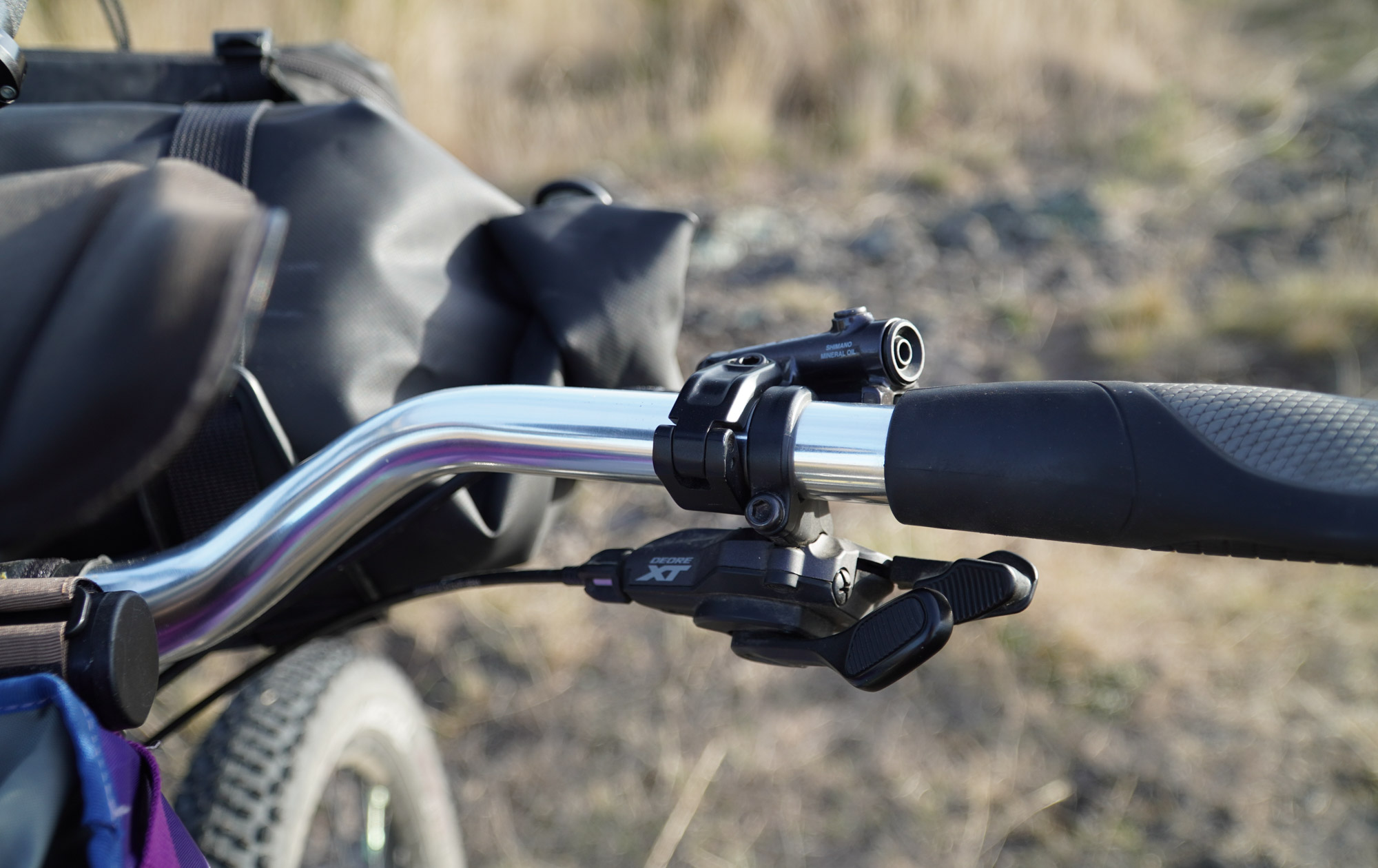 An XT trigger shifter sits next to a Shimano 6100 brake lever, with separate clamps for added adjustability.