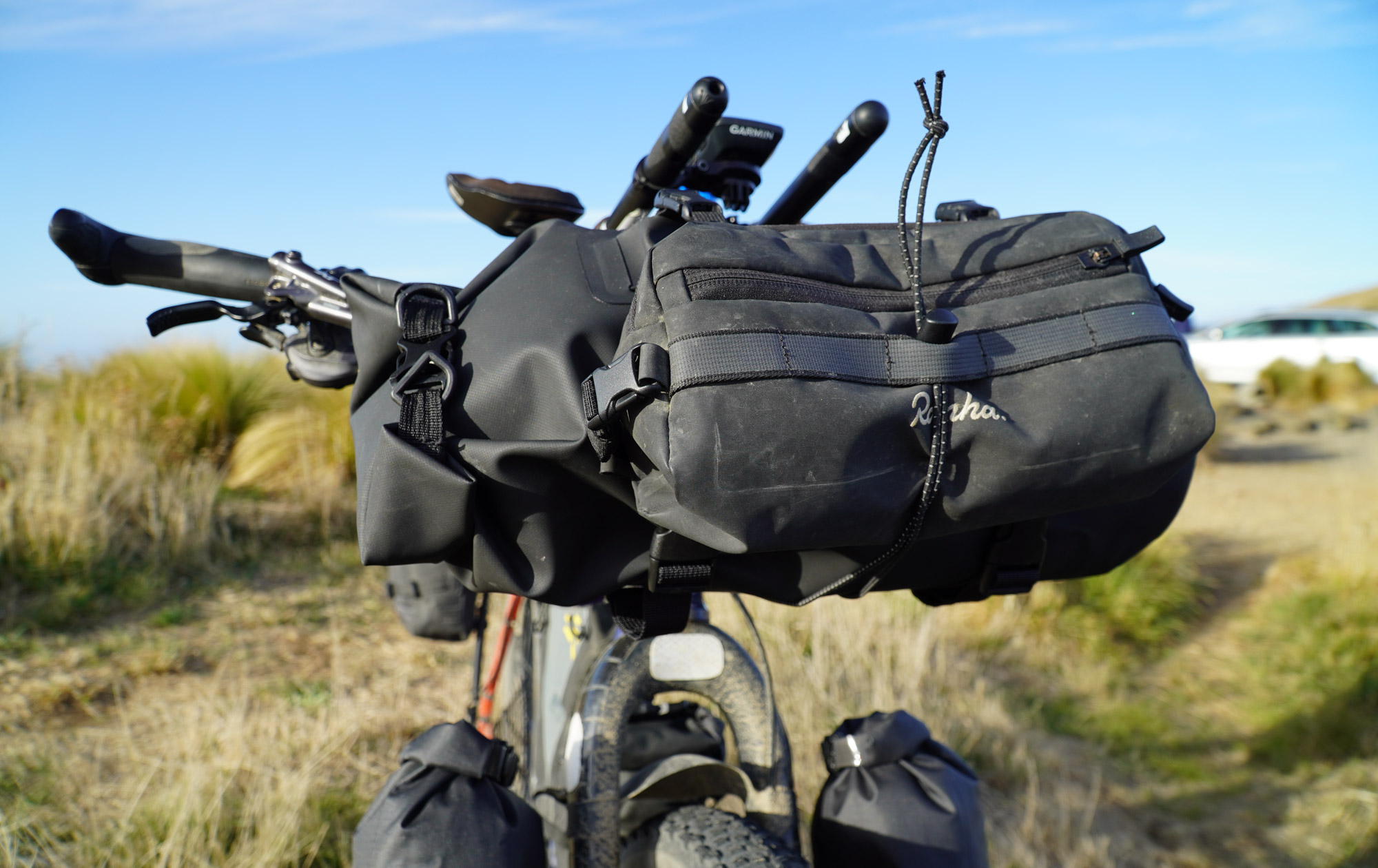 A Rapha handlebar bag is cinched down tight at the front of the bike.