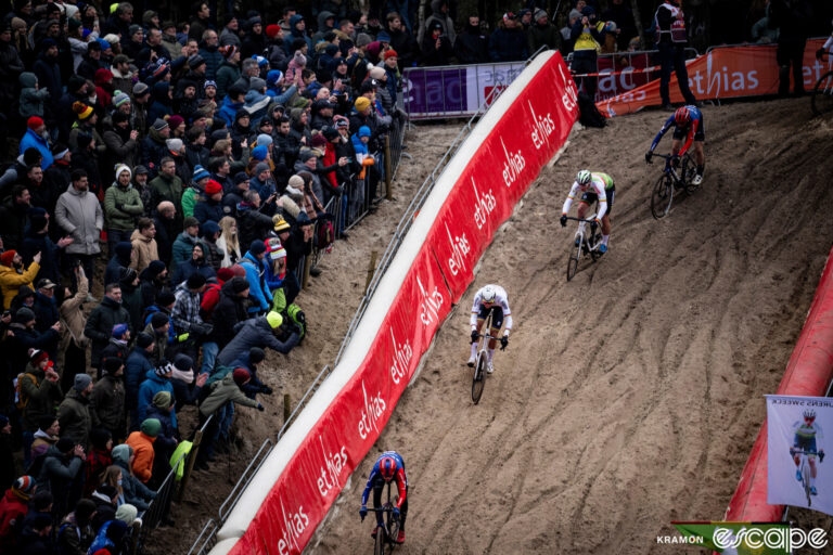Mathieu van der Poel descends into the famed "pit" on the sand dunes of the Zonhoven World Cup. Crowds of fans line the barriers, which are padded to protect riders in crashes.