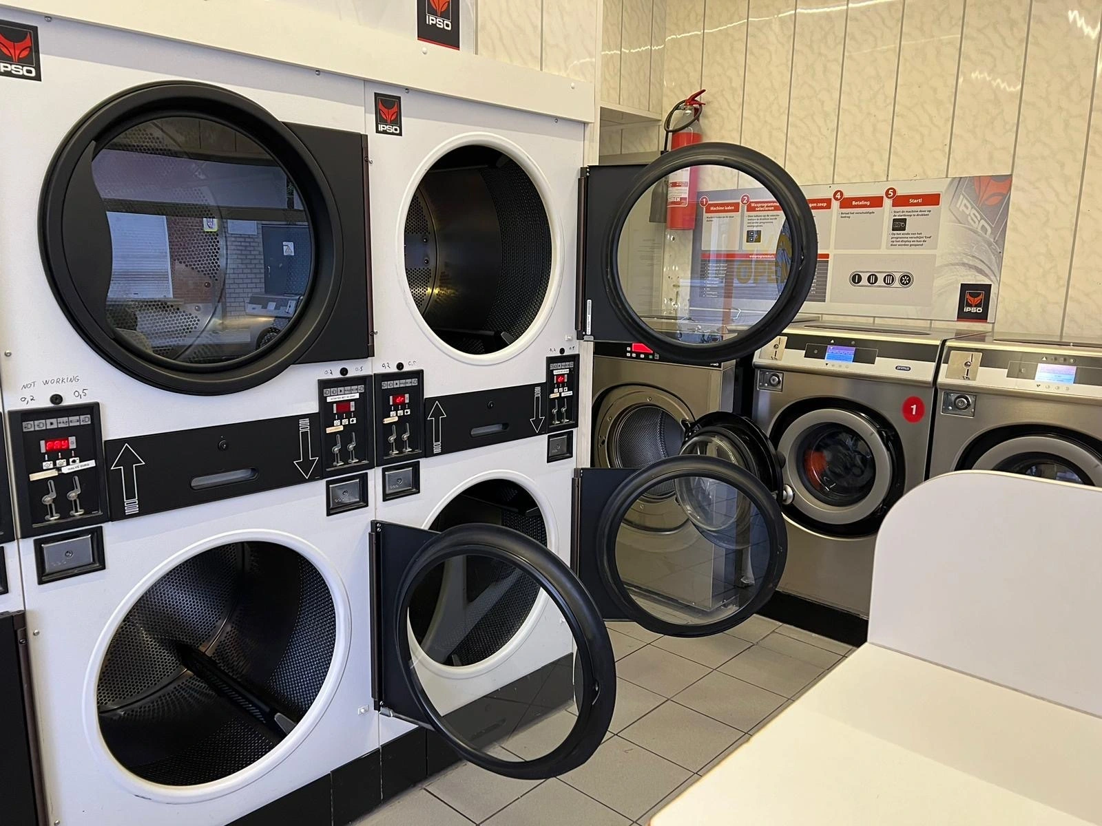 A laundromat with several washing machines and a folding table