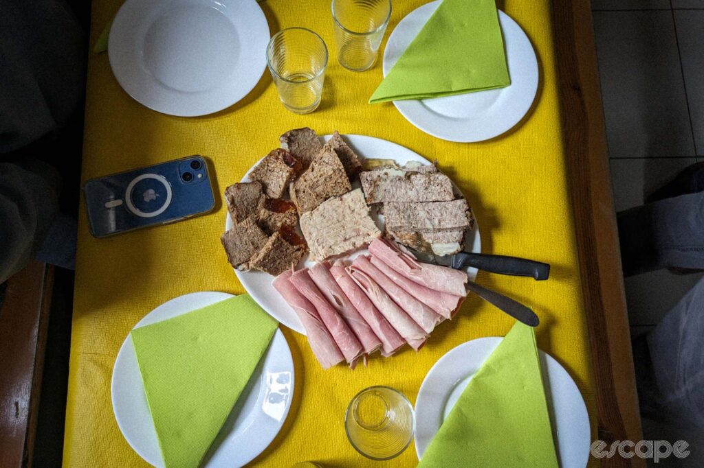 A selection of prepared meats and cold cuts sits on a table, mostly untouched.