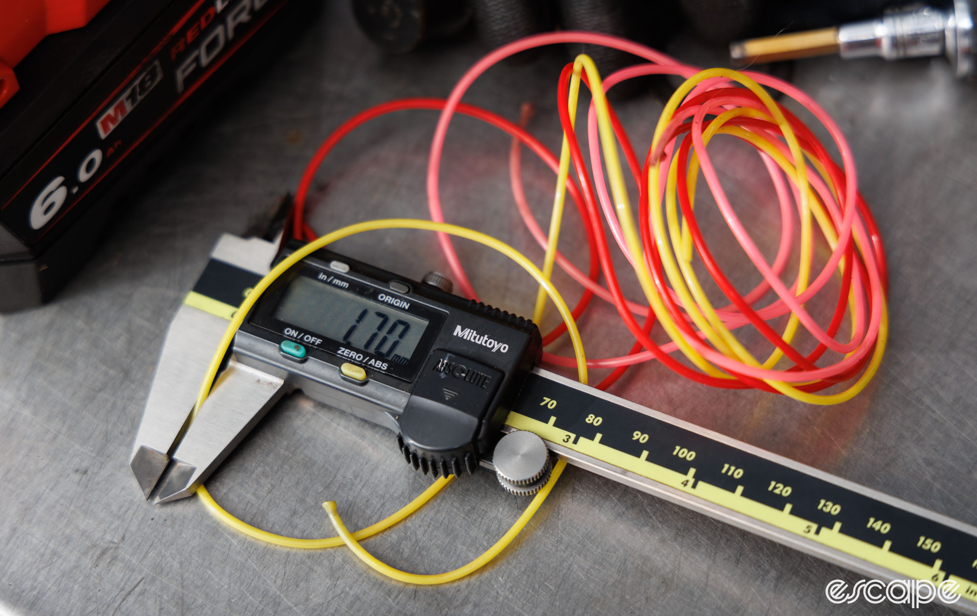 A collection of colourful plastic braiding cords being measured. The calipers show an external diameter of 1.7 mm. 