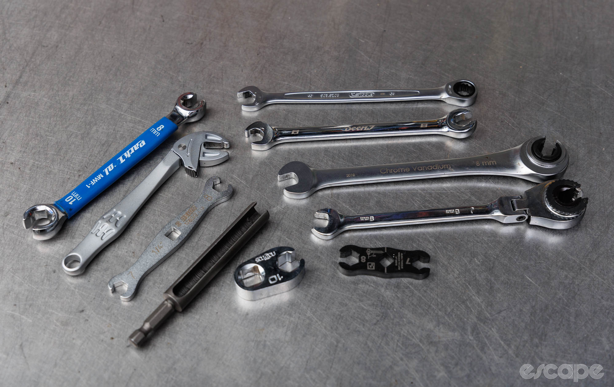 Ten different tools on a bench, all with the purpose of tightening 8 mm disc brake hose nuts. 