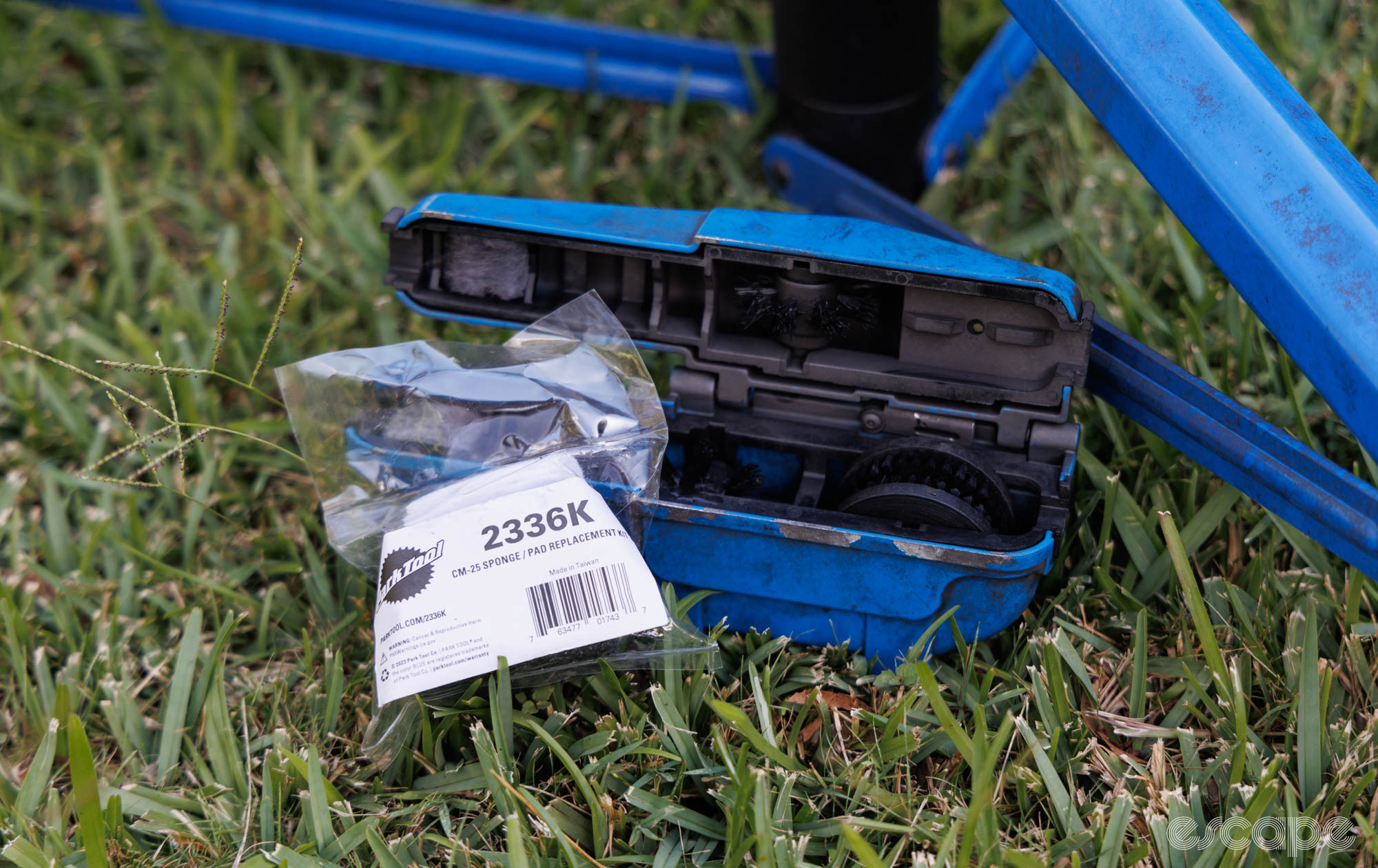 Park Tool CM-25 chain cleaner on grass with the new sponge kit. The legs of a Park Tool repair stand sit in the photo. 