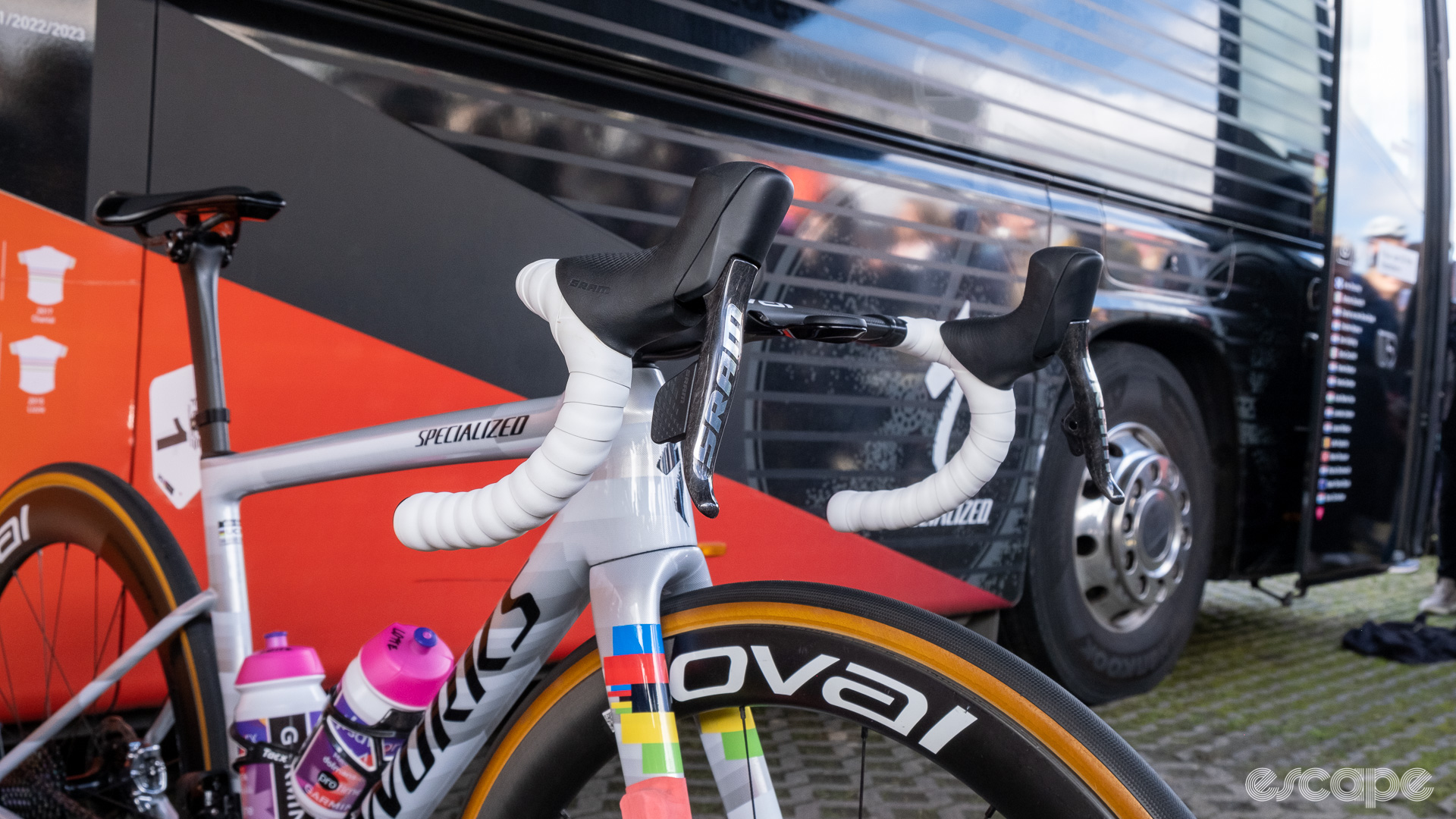 The image shows SRAM Red AXS levers on white bar tape on Lotte Kopecky's bike. 