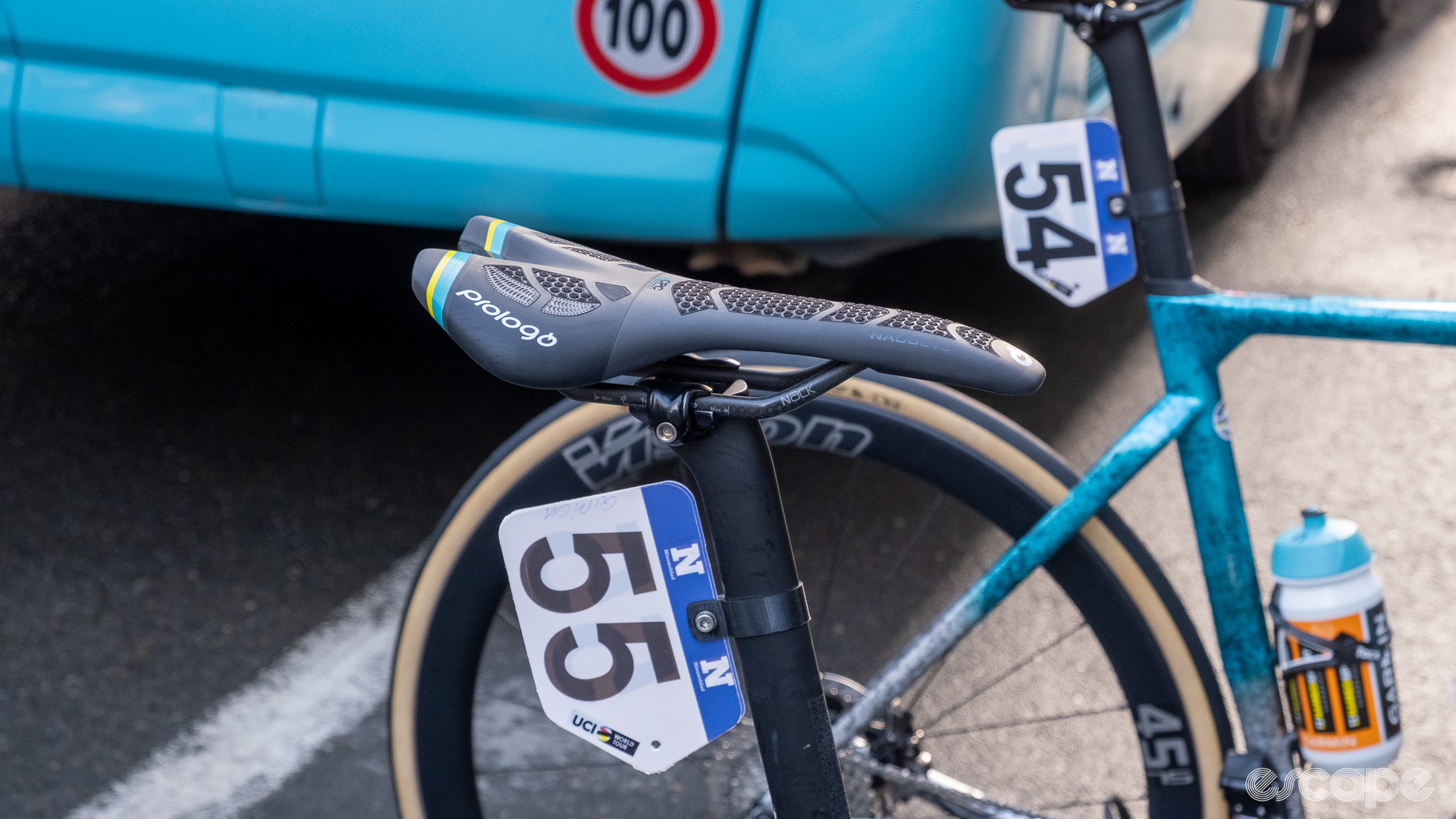 The image shows a Prologo saddle with the seat post mounted on the middle of the rails.