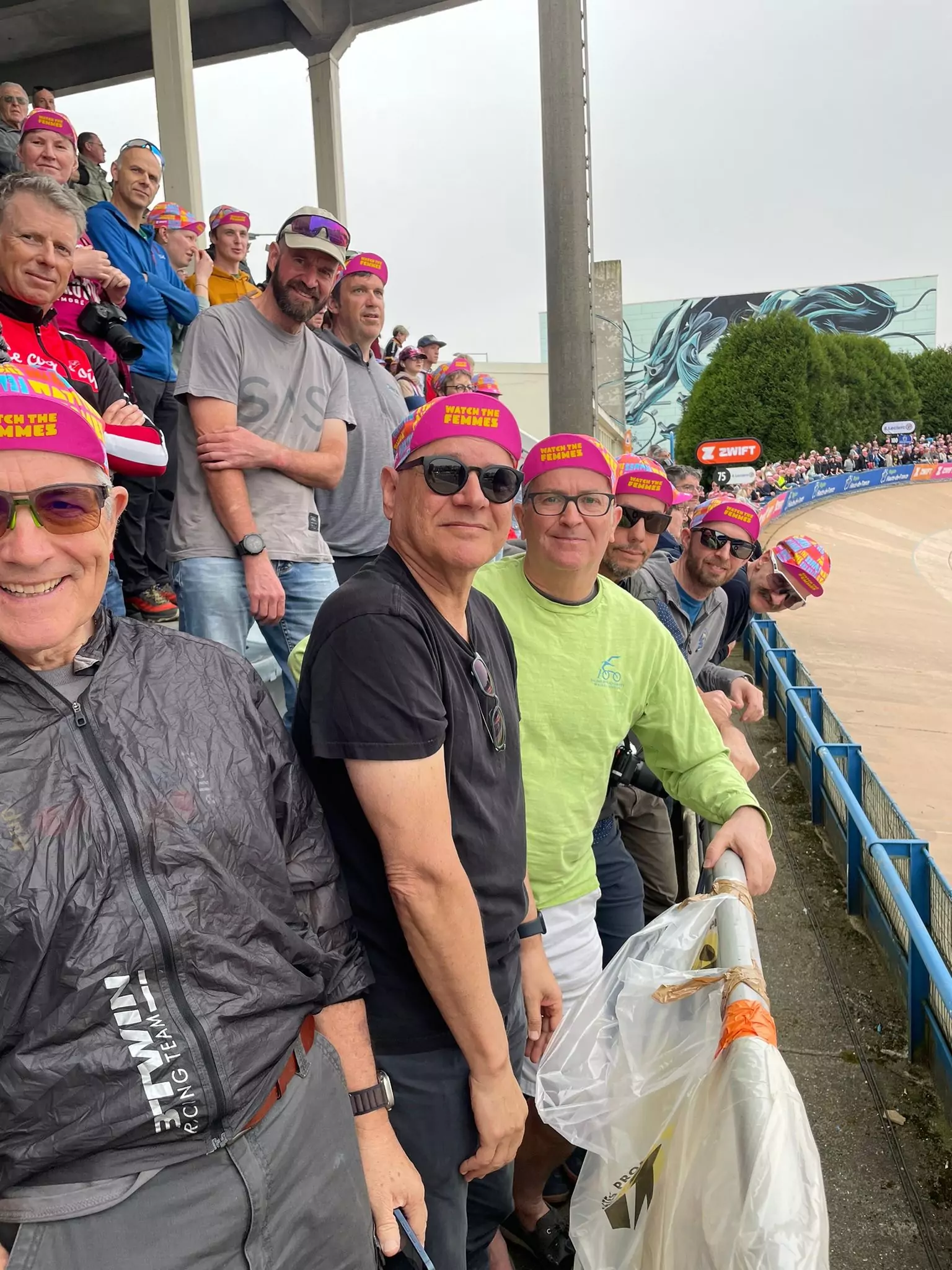 A row of cycling fans spectating from the Roubaix velodrome stands