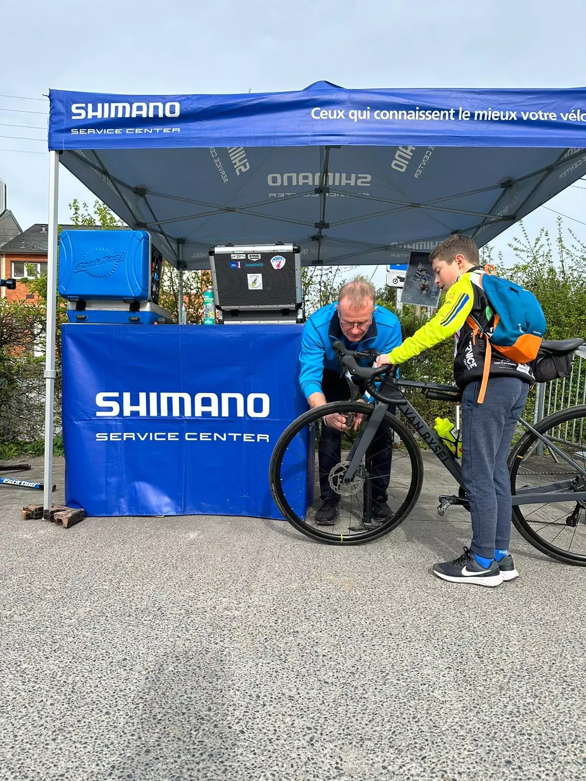 A Shimano employee inflating young boy's road bike tires