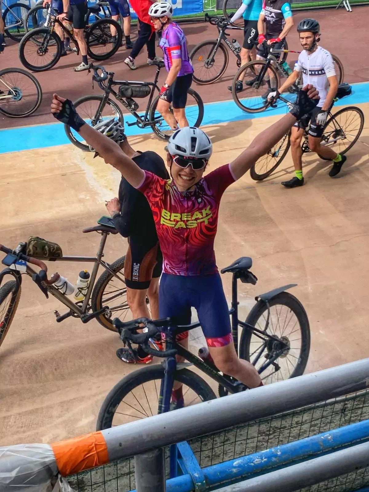 Claire Law raises her arms in celebration from the velodrome after finishing the Roubaix Sportif