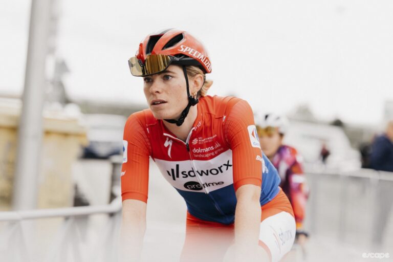 Demi Vollering rides to the final stage of La Vuelta wearing the red leader's jersey, she is focused.