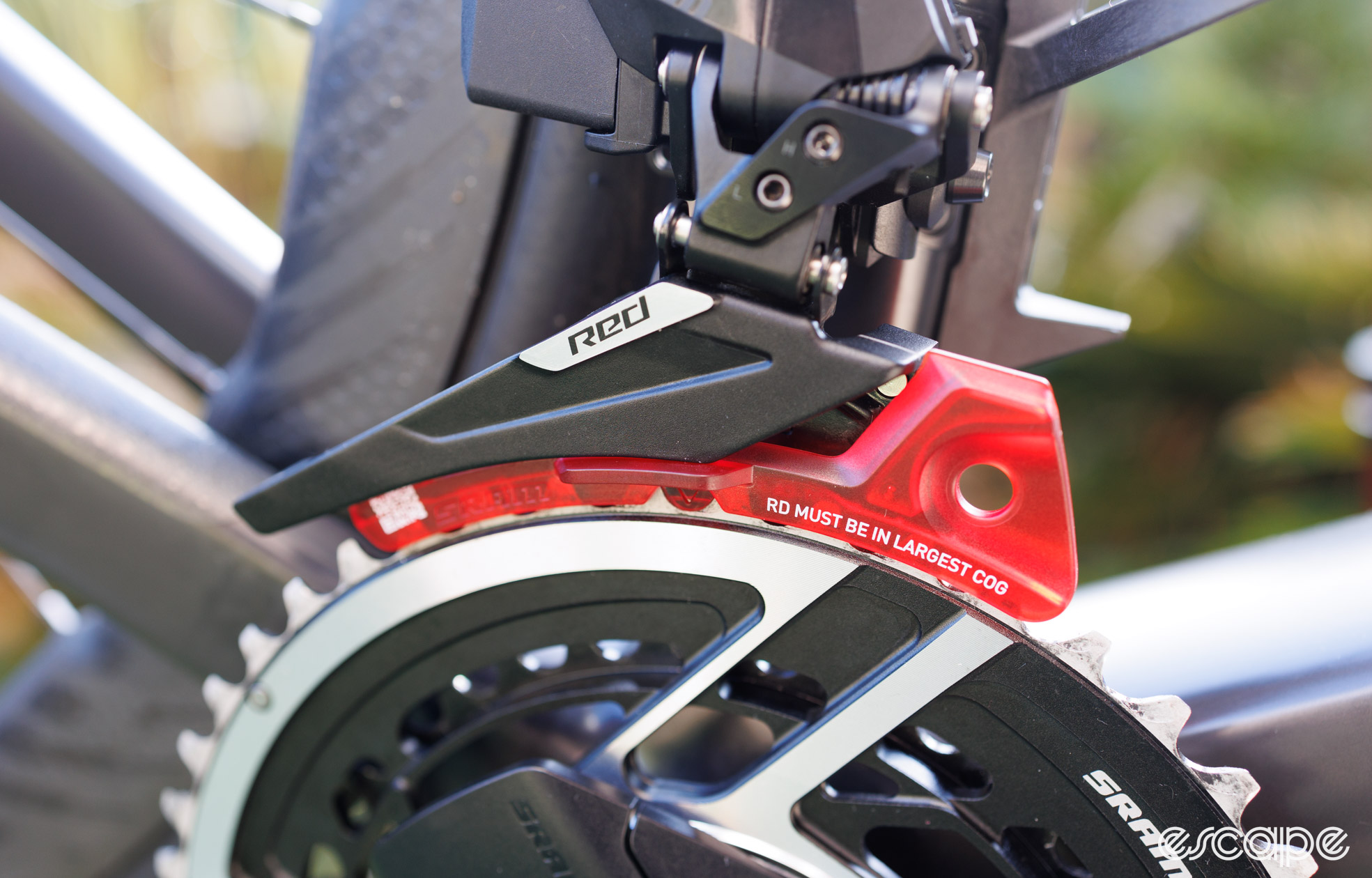 A plastic derailleur alignment tool is inserted into the new SRAM Red AXS front derailleur. Shown from the side. 